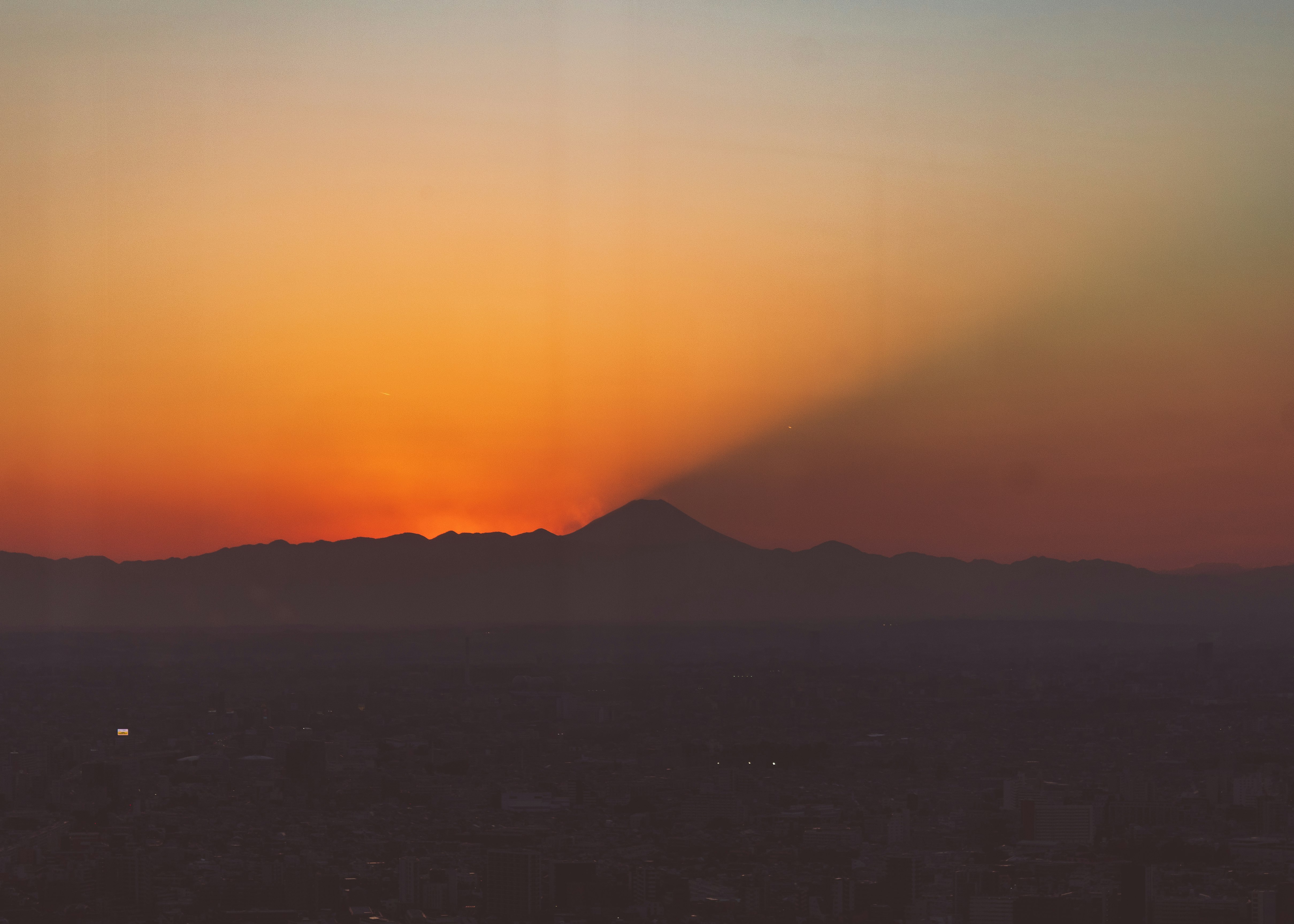 夕暮れの空と遠くに浮かぶ山のシルエット