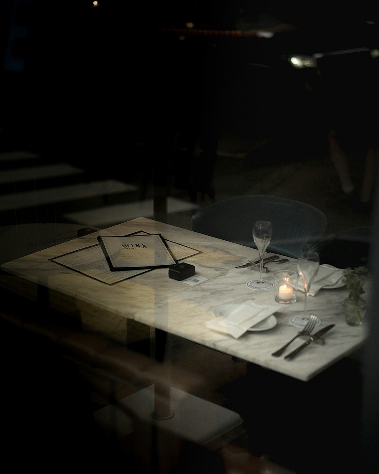昏暗的餐廳桌上放著蠟燭和餐具