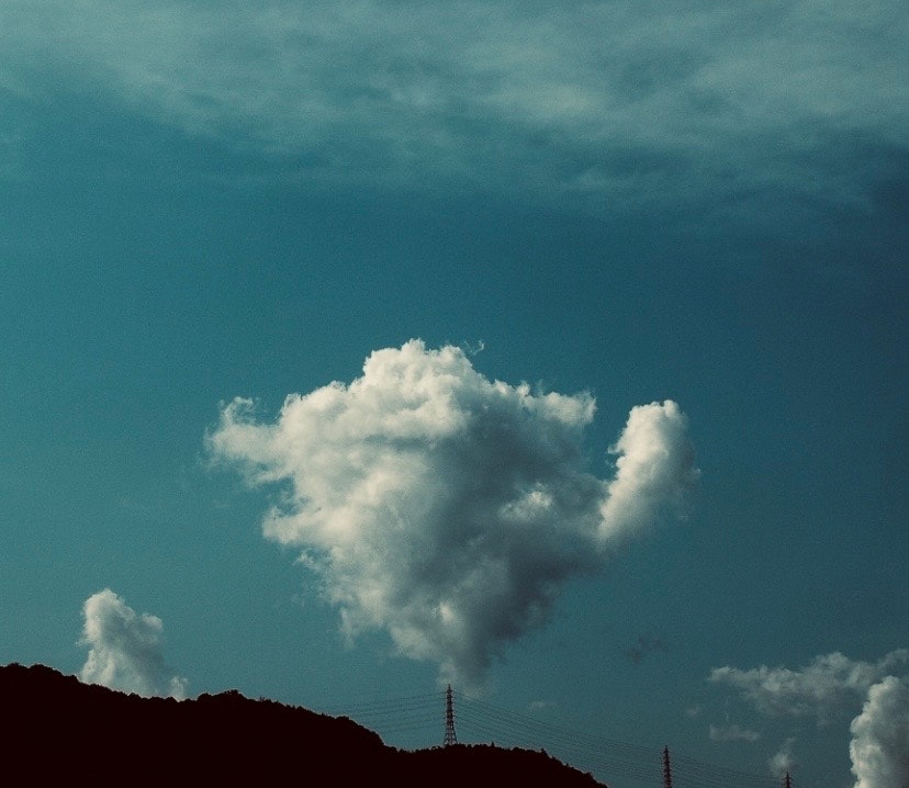 丘の稜線にかかる大きな雲の空