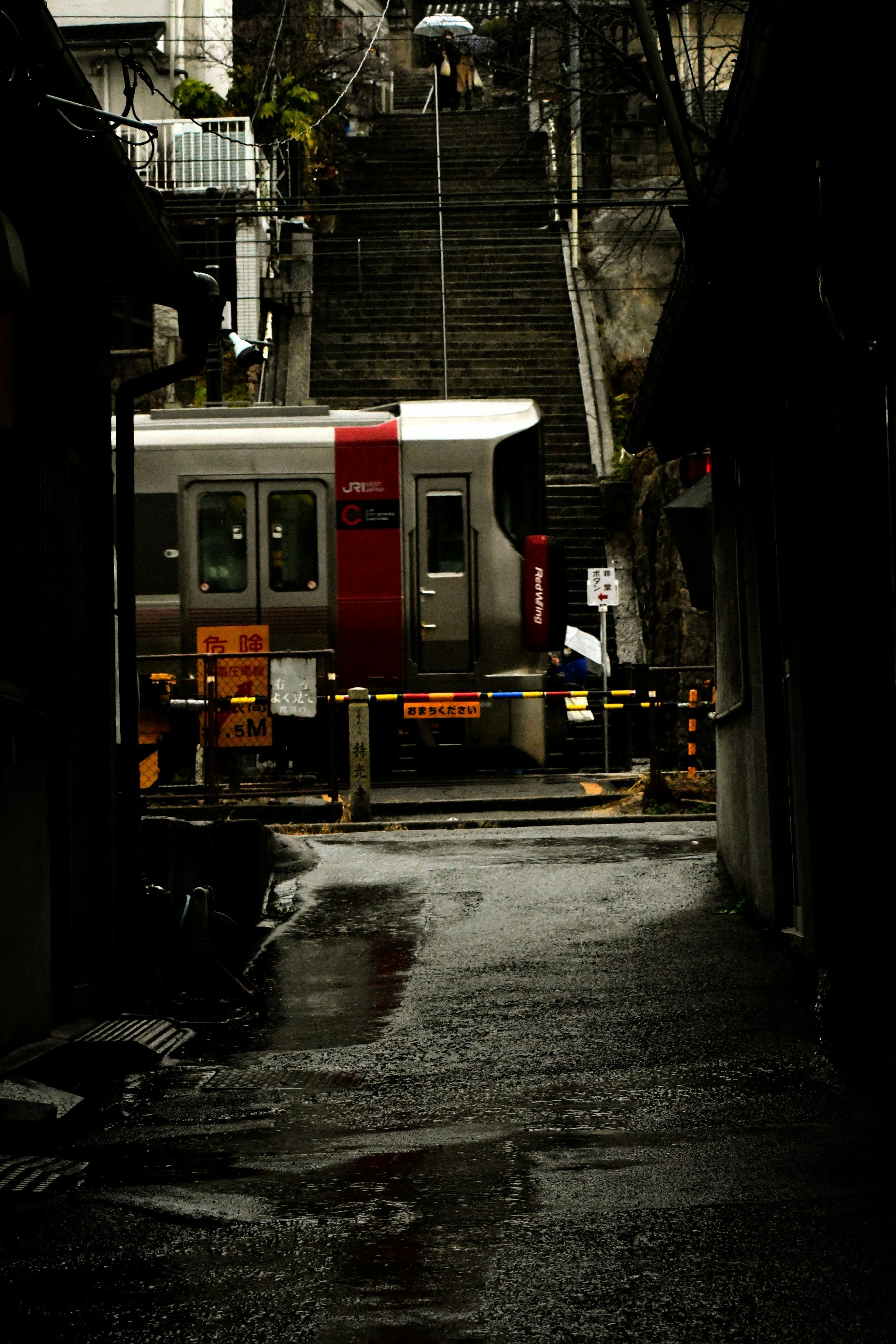 尾道の路地にある階段とバス停のある狭い通りの風景