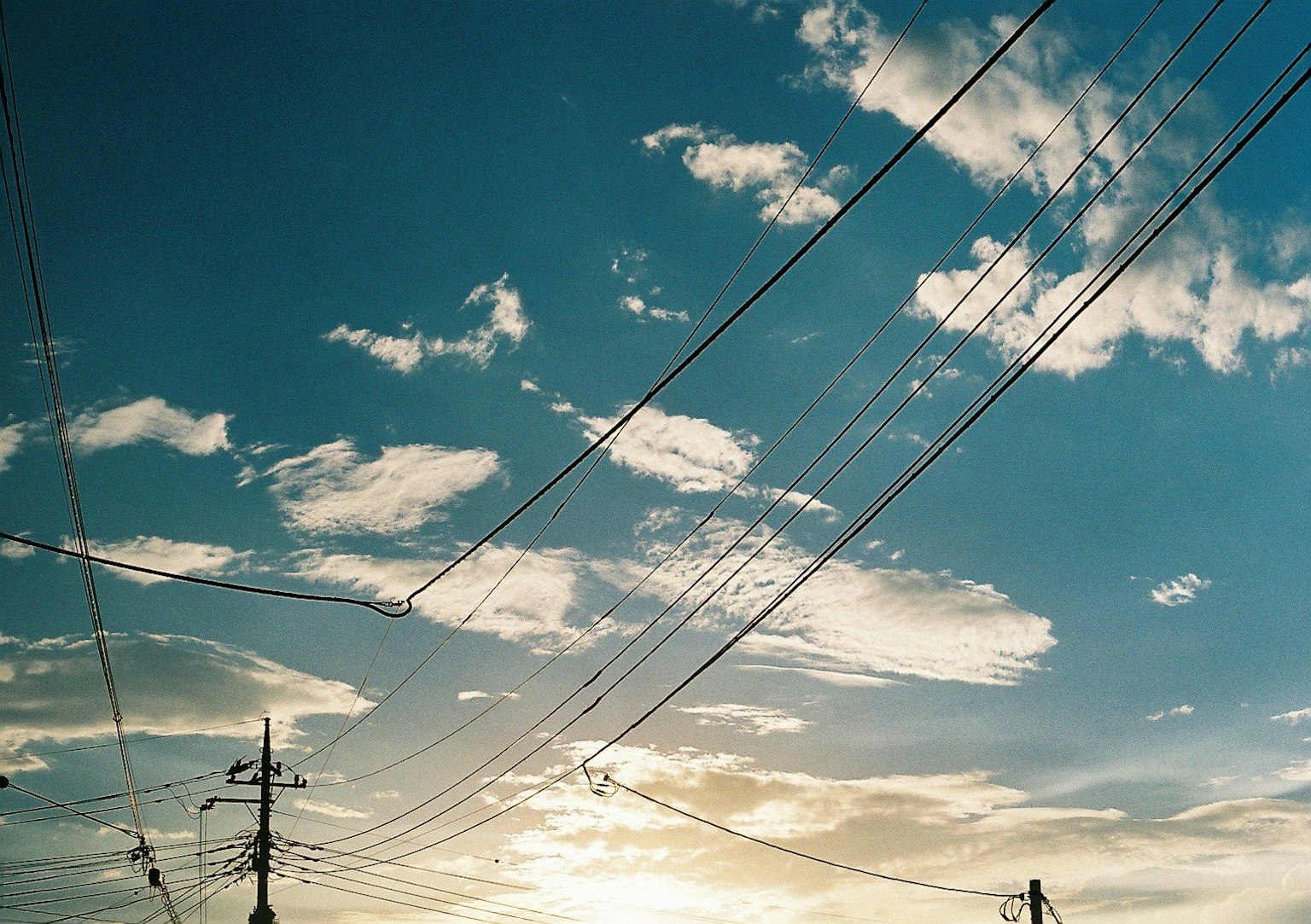 เงาของสายไฟฟ้าในท้องฟ้าสีฟ้าพร้อมเมฆ