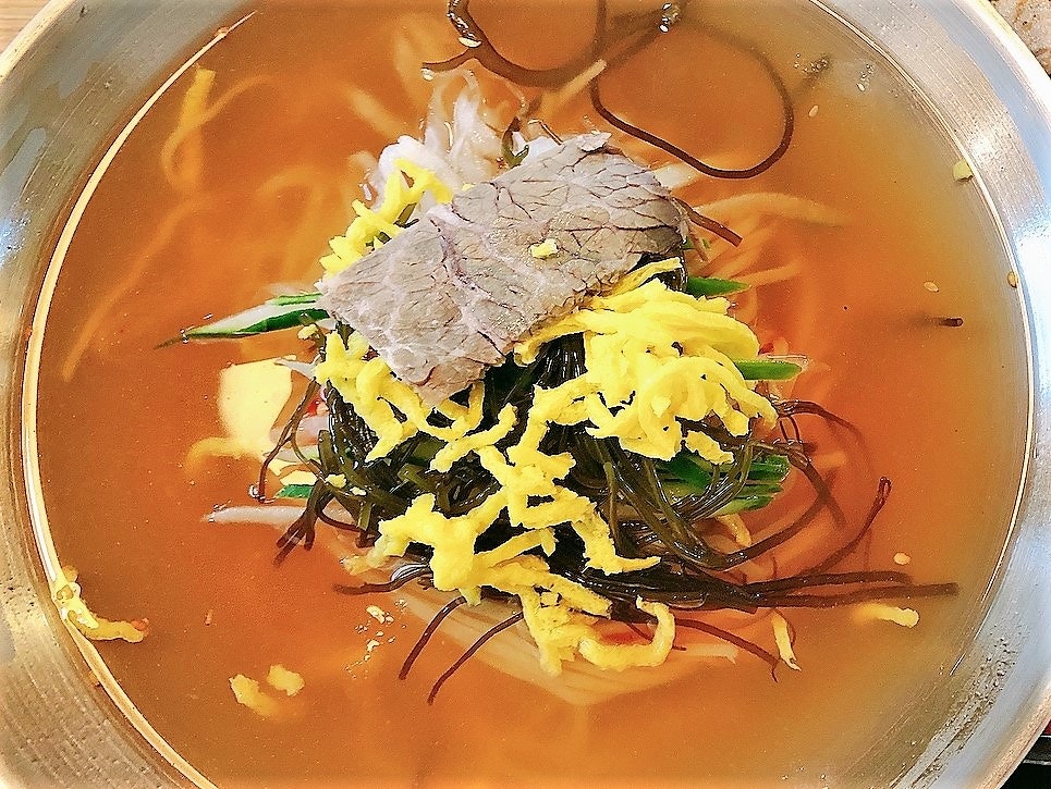 透明なスープに盛られた細切れの肉と色とりどりの野菜