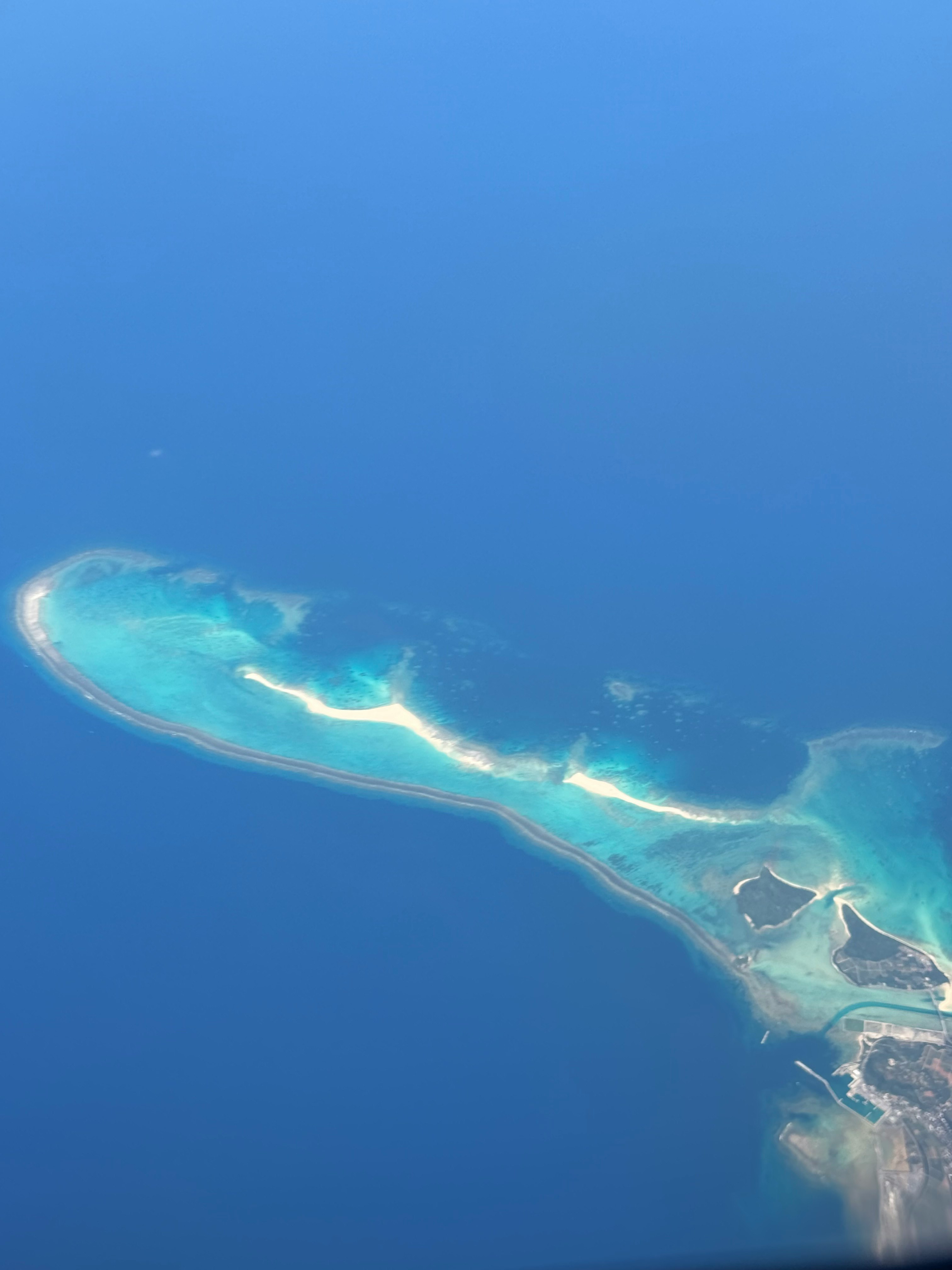 久米島の青い海と砂浜の海岸線の空撮画像