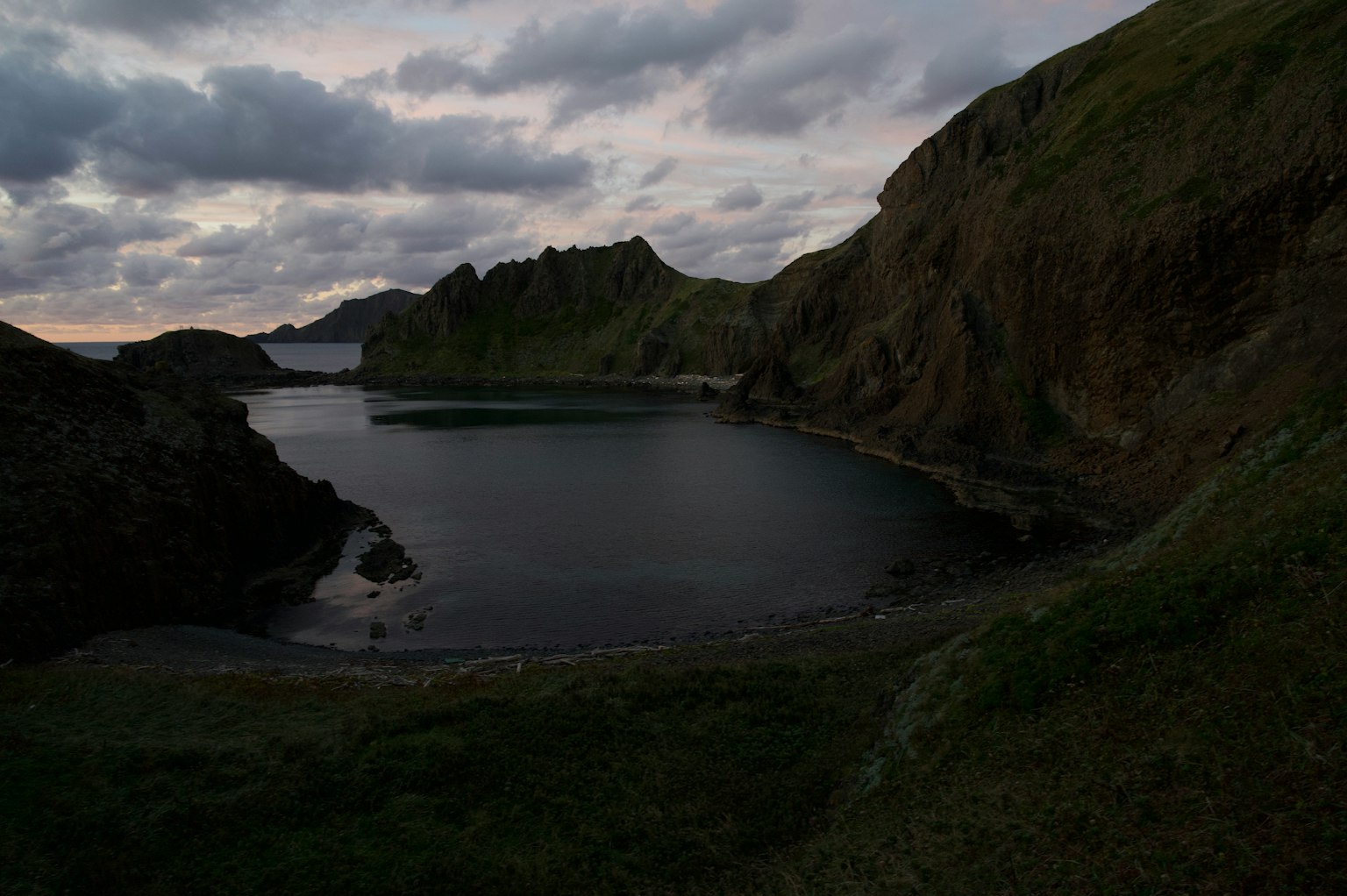 Serene bay landscape with dark coastline and rocky formations