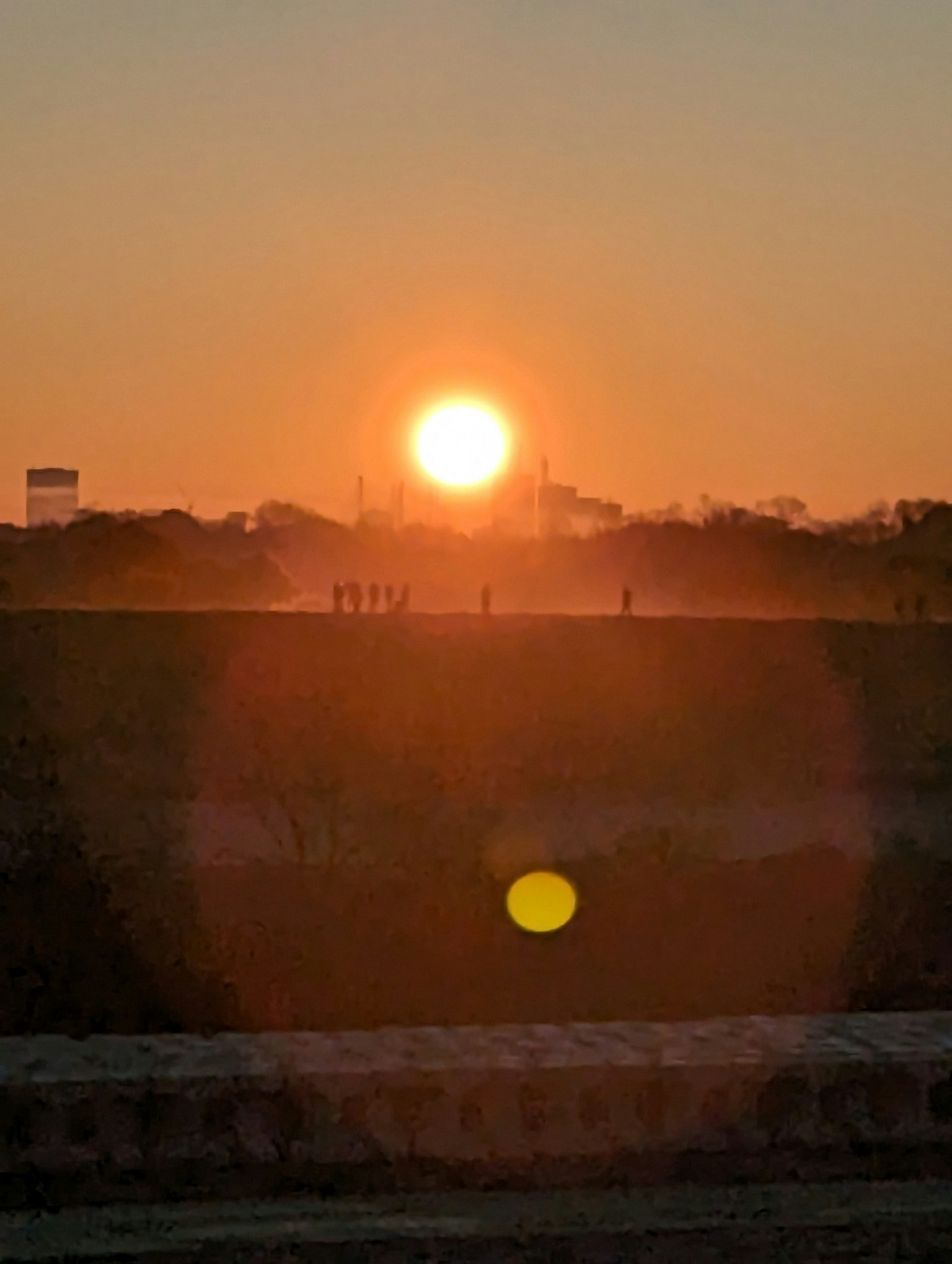 Atardecer con figuras en silueta contra el horizonte