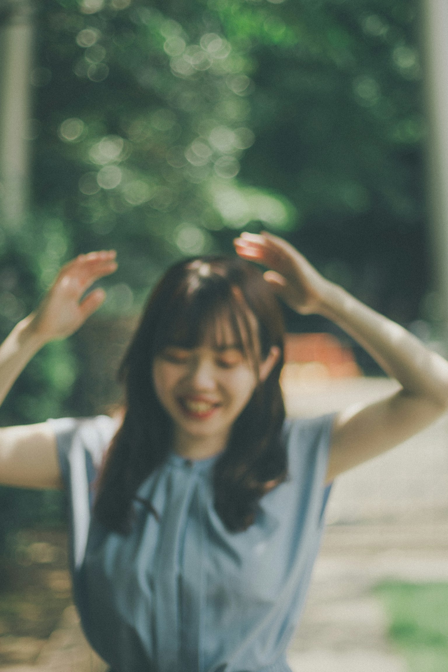 一位在绿色背景下微笑并举起双手的女性