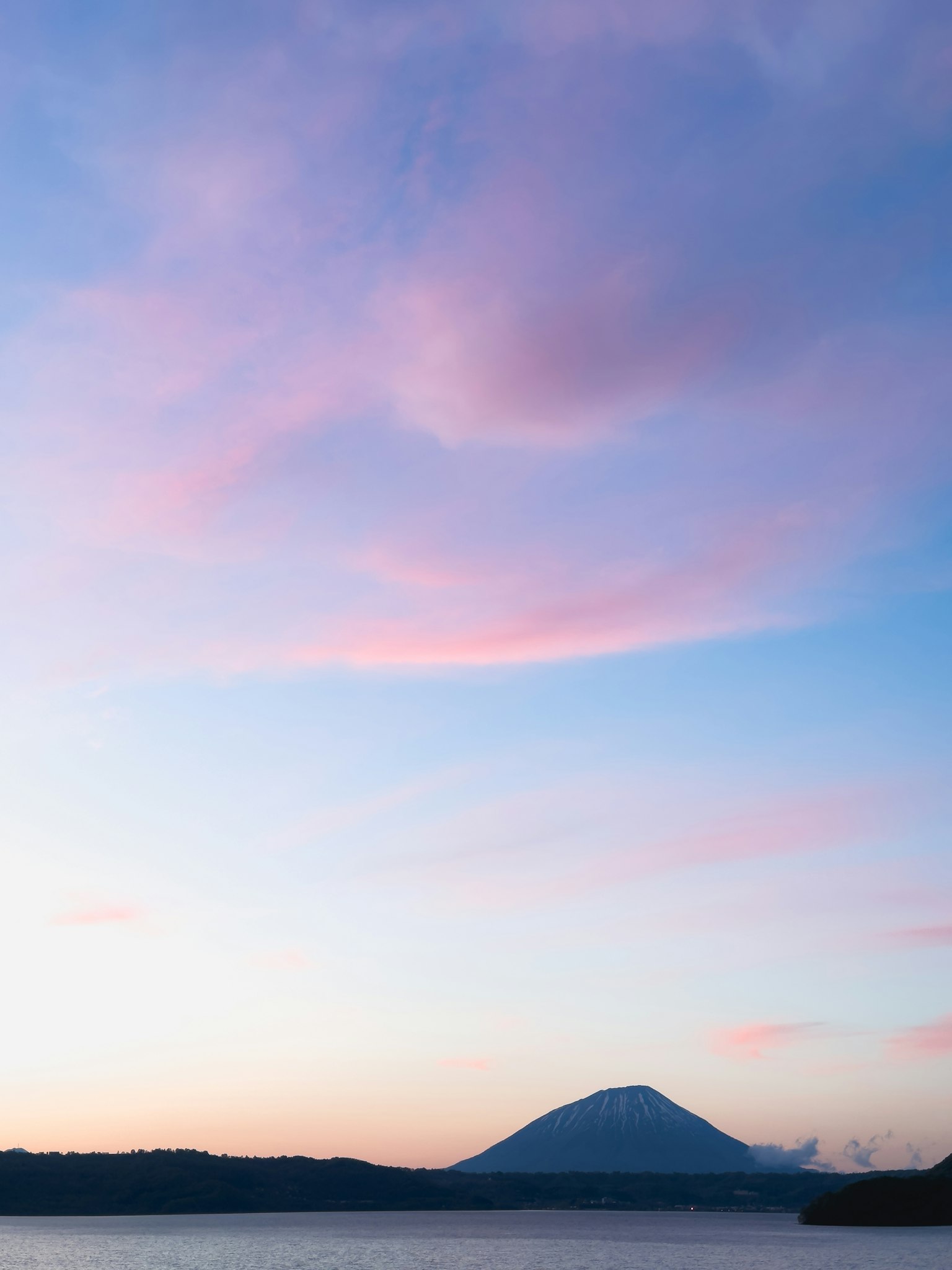Pemandangan indah langit senja berwarna dengan gunung di latar belakang