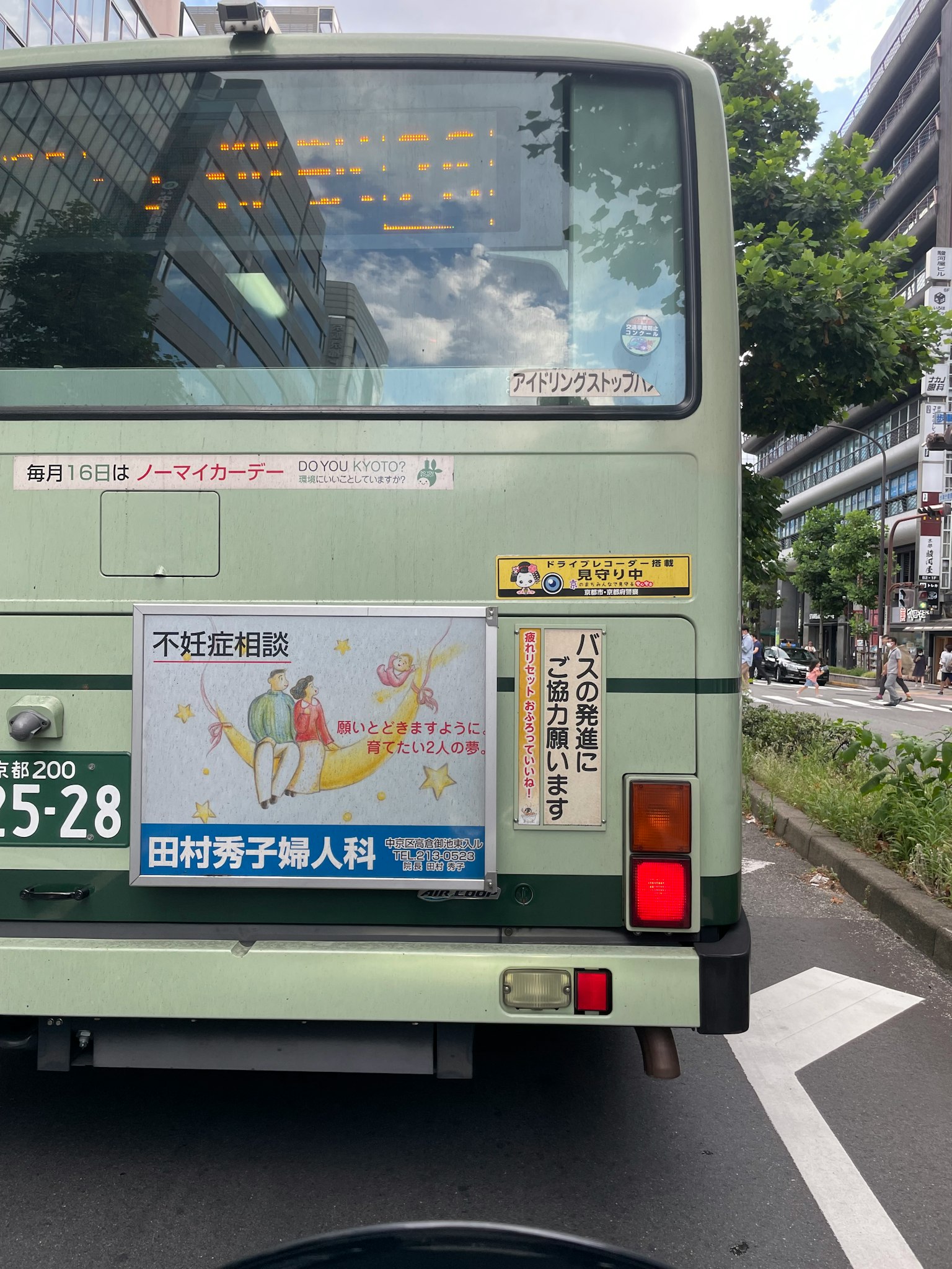 一輛後面有廣告的綠色公車