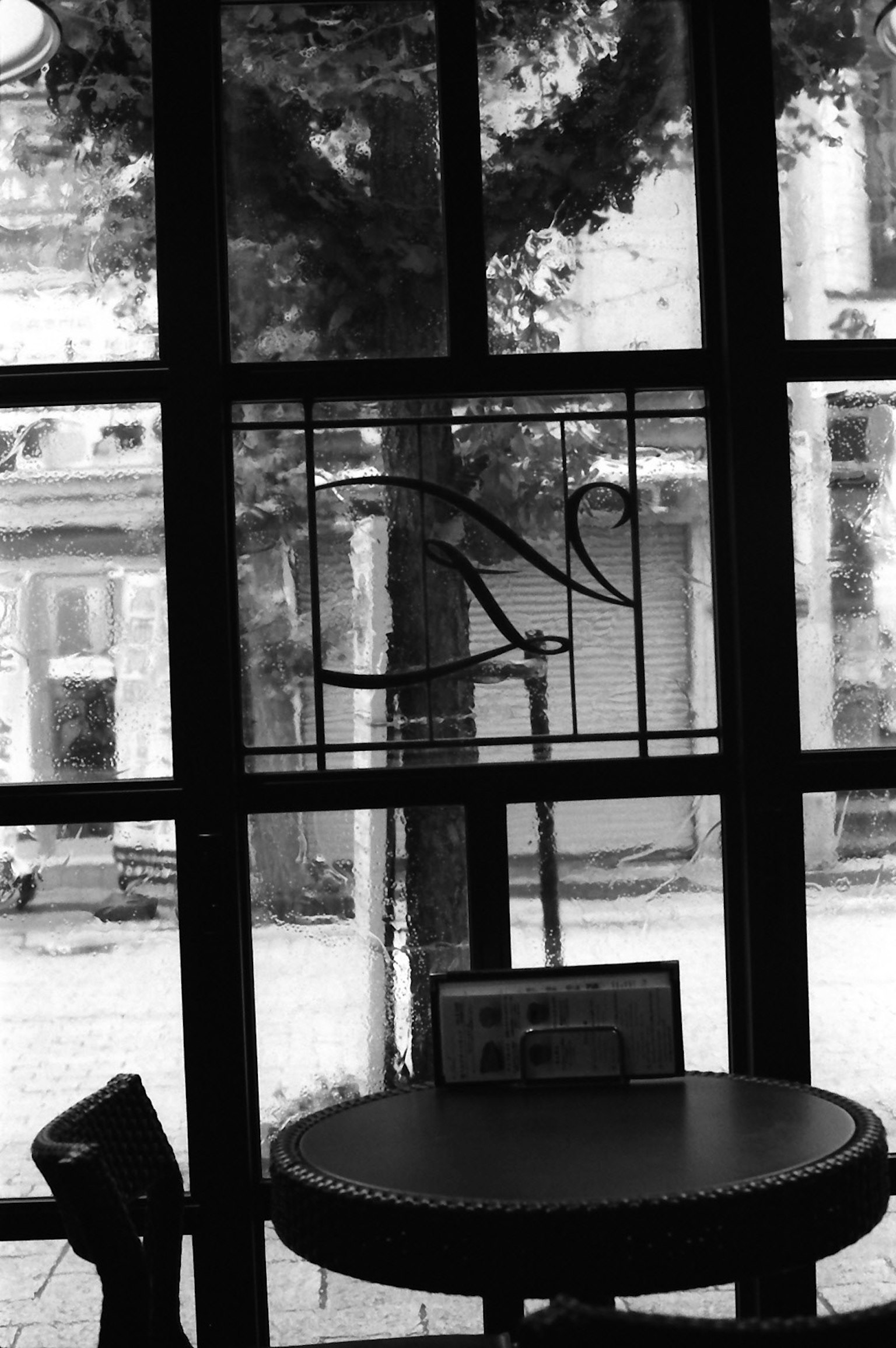 Interno di un caffè visto attraverso una finestra con un tavolo e sedie