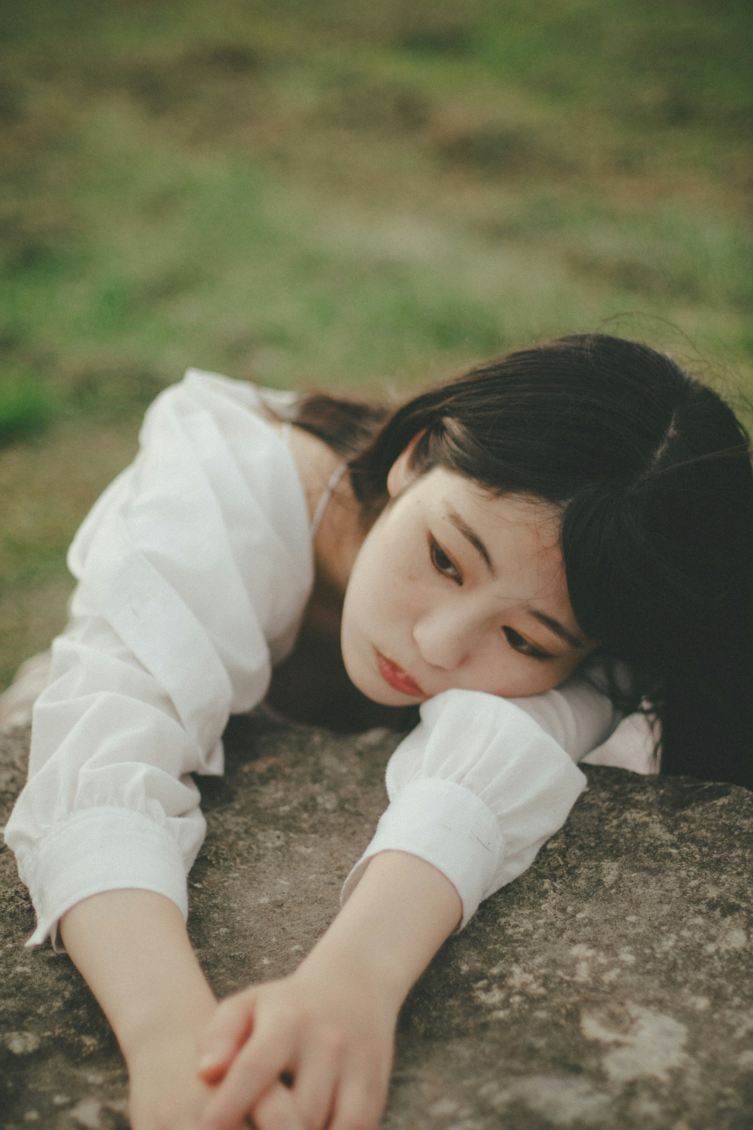 자연 환경에서 편안한 분위기로 돌 위에 누워 있는 젊은 여성