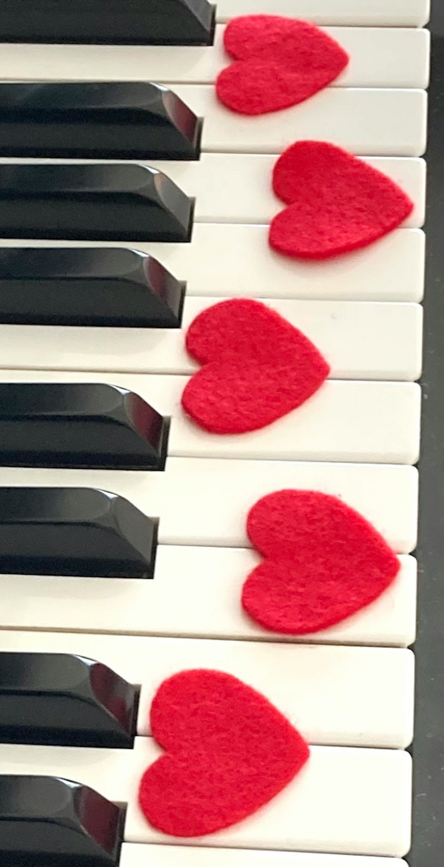 Decoraciones en forma de corazón rojo en las teclas del piano
