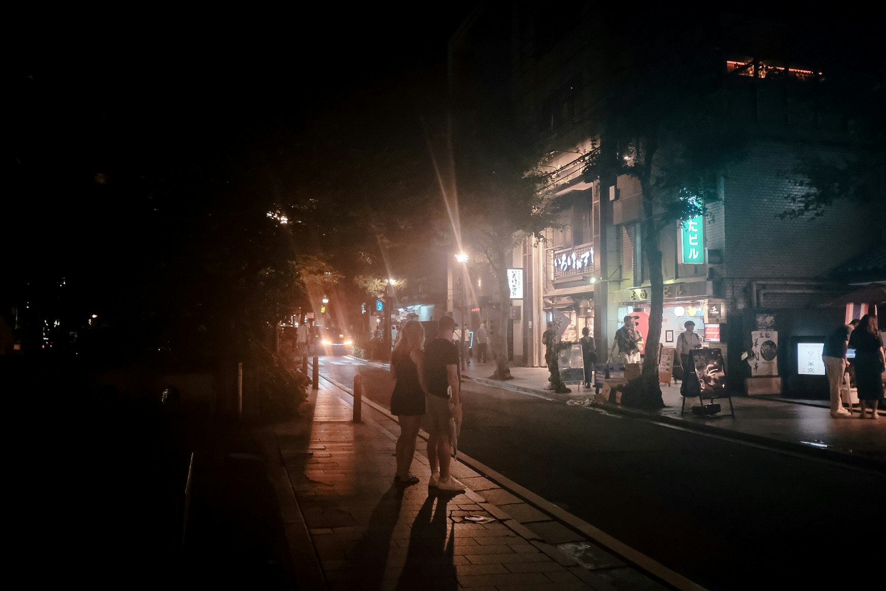 scène de rue nocturne à Kyoto avec des passants