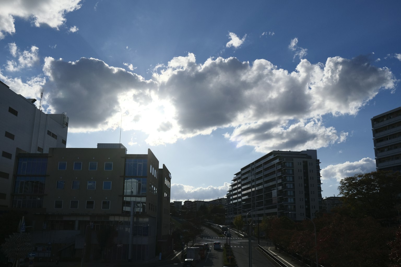 Paysage urbain avec ciel bleu et nuages comprenant des bâtiments et une route