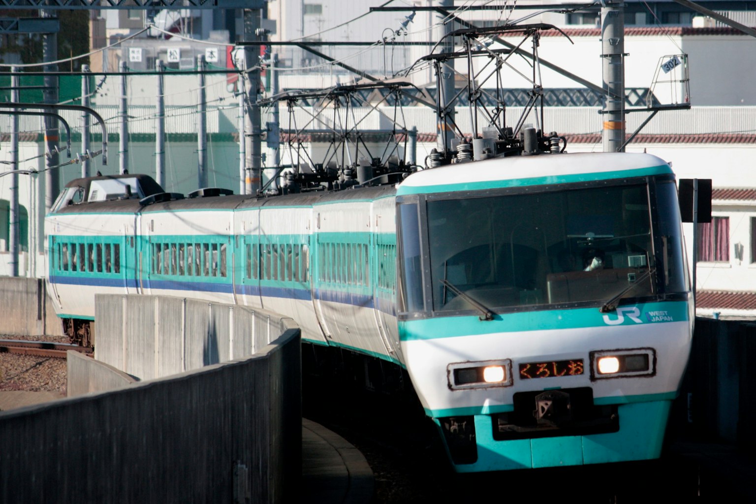 Treno con striscia blu che viaggia sui binari