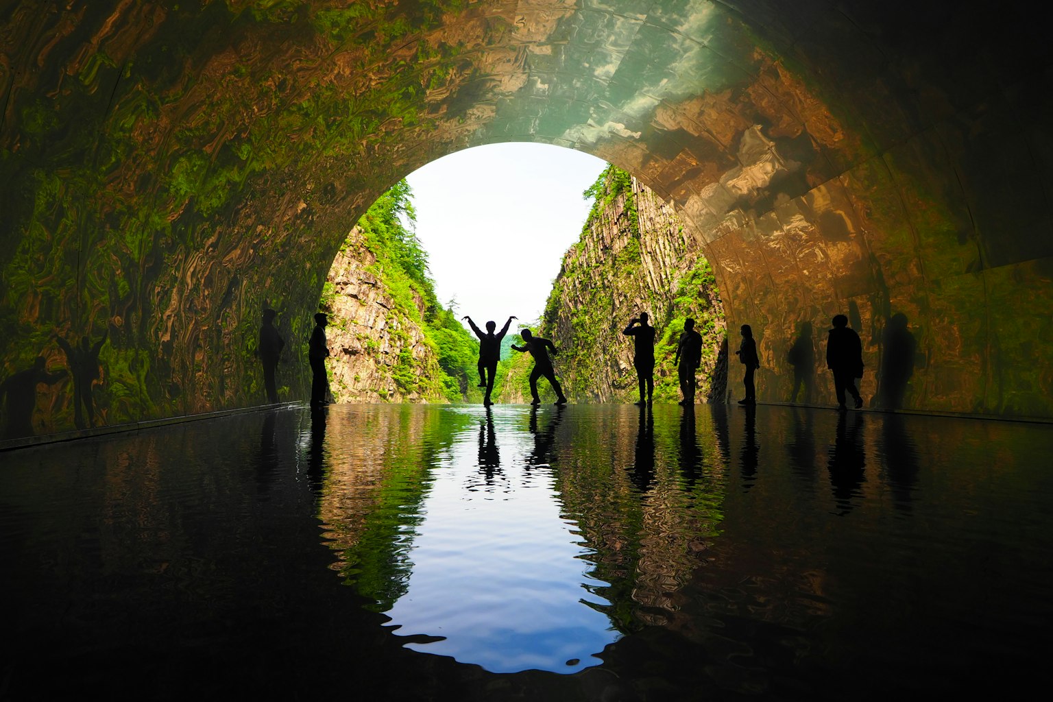 Silhouettes de personnes dans une grotte réfléchies sur l'eau