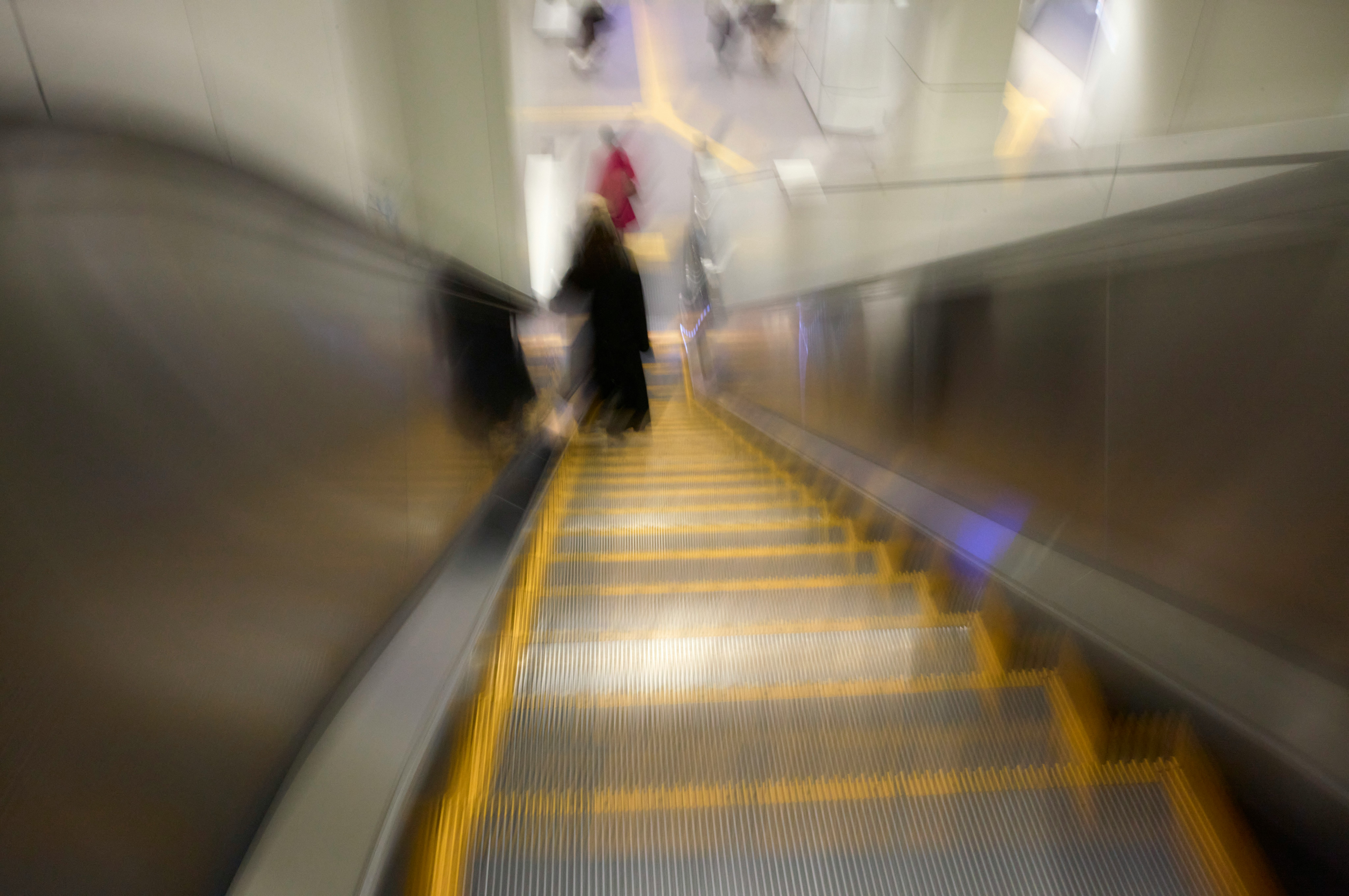 vue en profondeur d’un escalator avec une personne qui descend