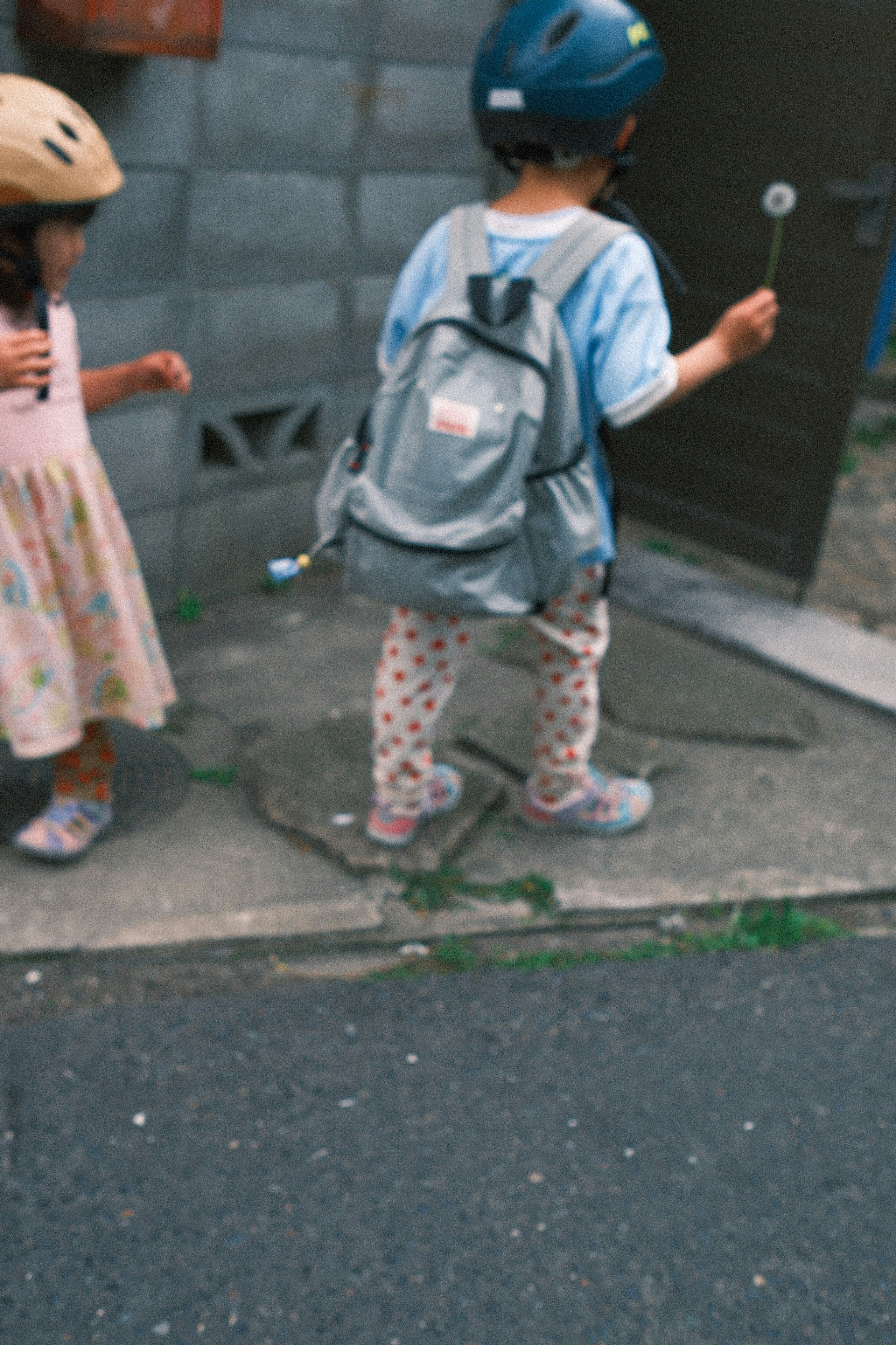 Children wearing bicycle helmets playing on a street