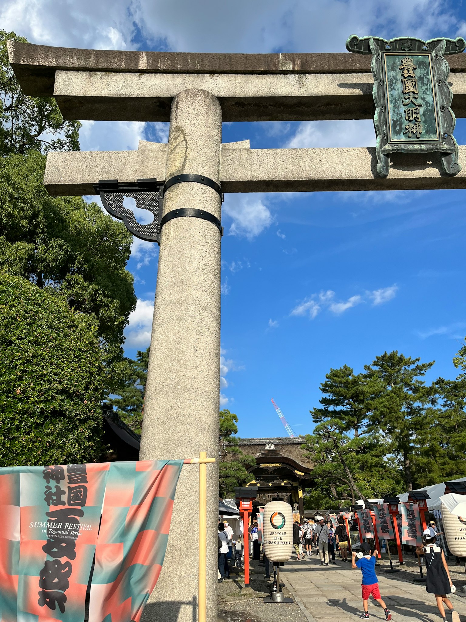 Puerta torii de un santuario con personas bajo un cielo azul