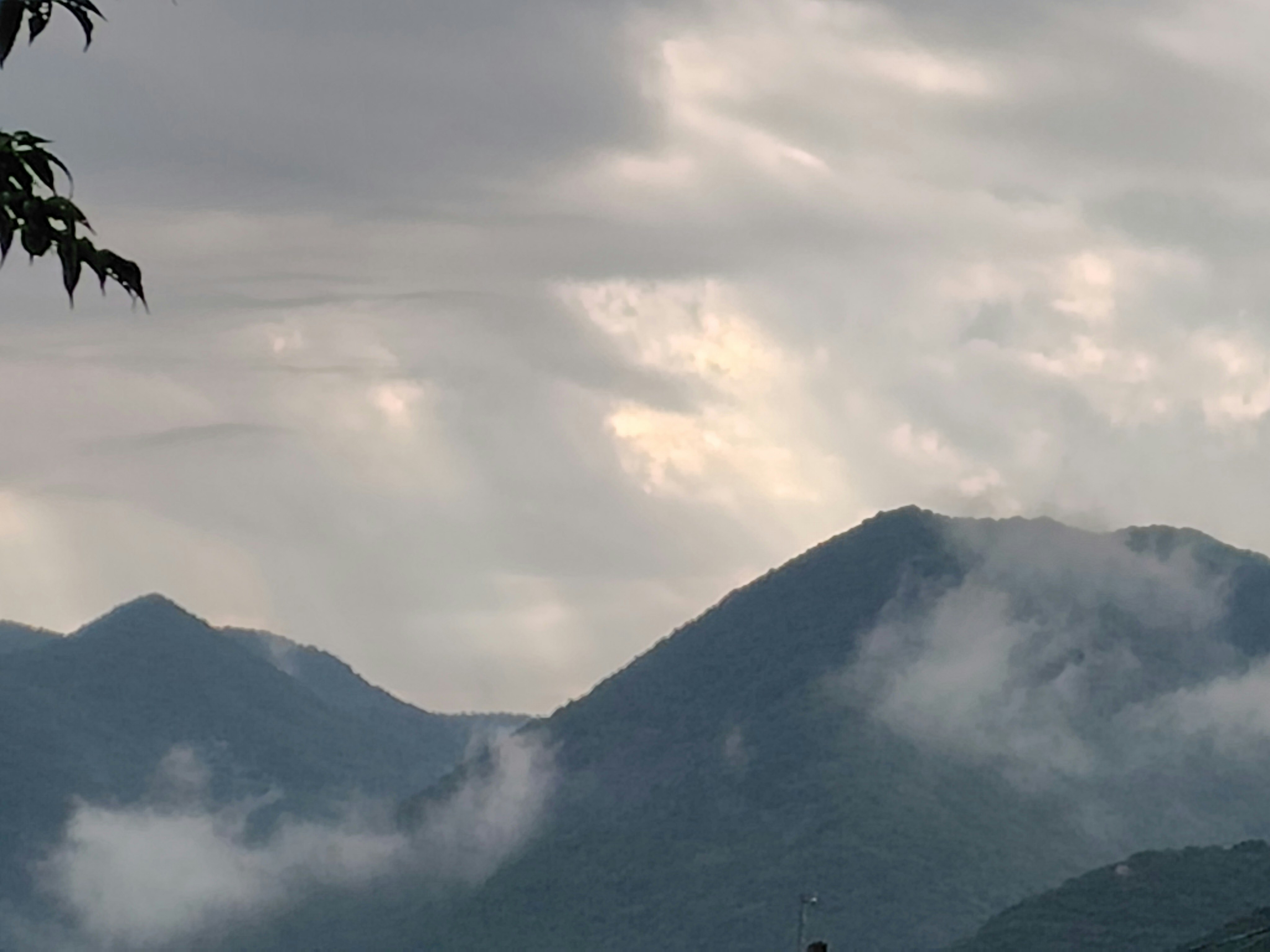 霧のかかった山並みと雲の広がる空