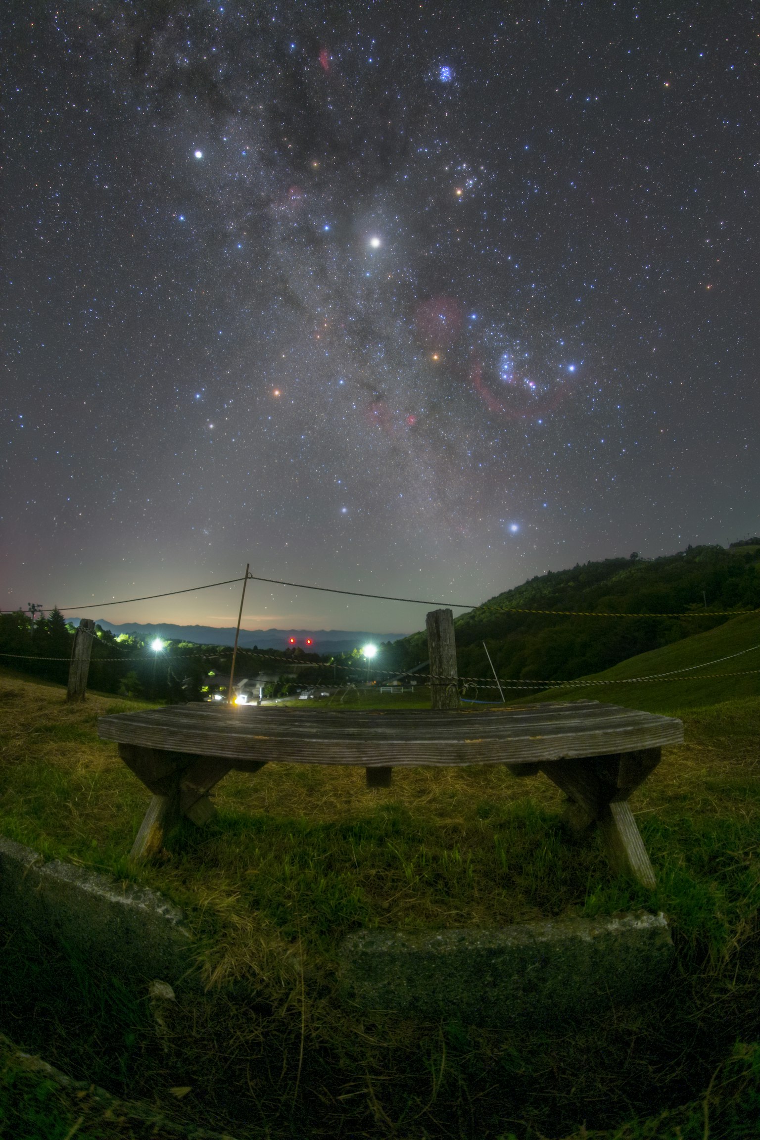 Banco de madera bajo un cielo estrellado con la Vía Láctea