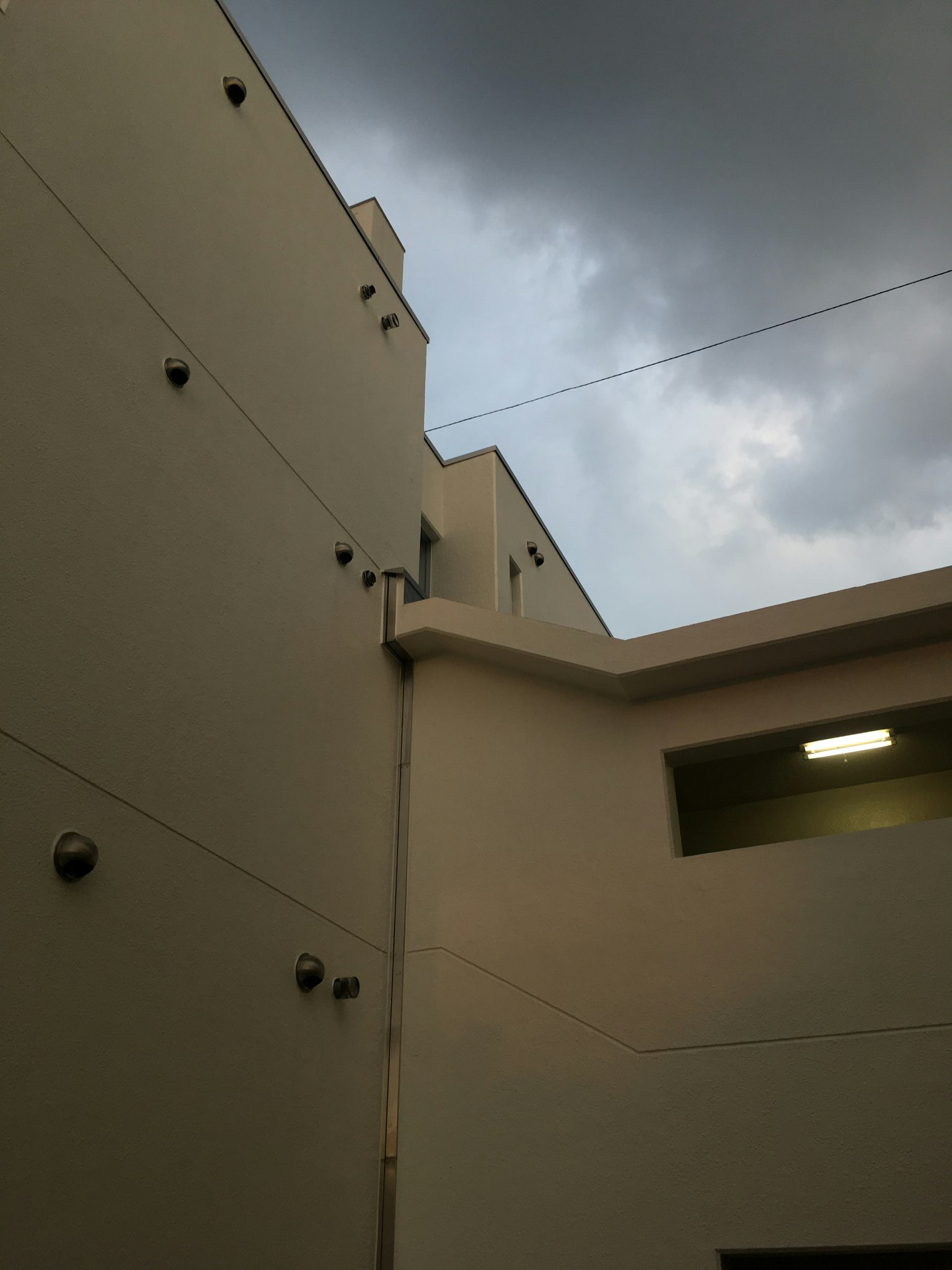 Parte del exterior de un edificio bajo nubes grises