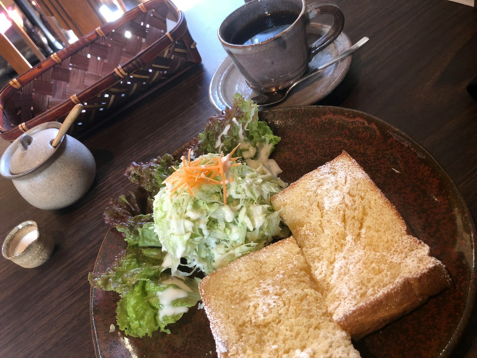 Piatto con toast e insalata insieme a una tazza di caffè