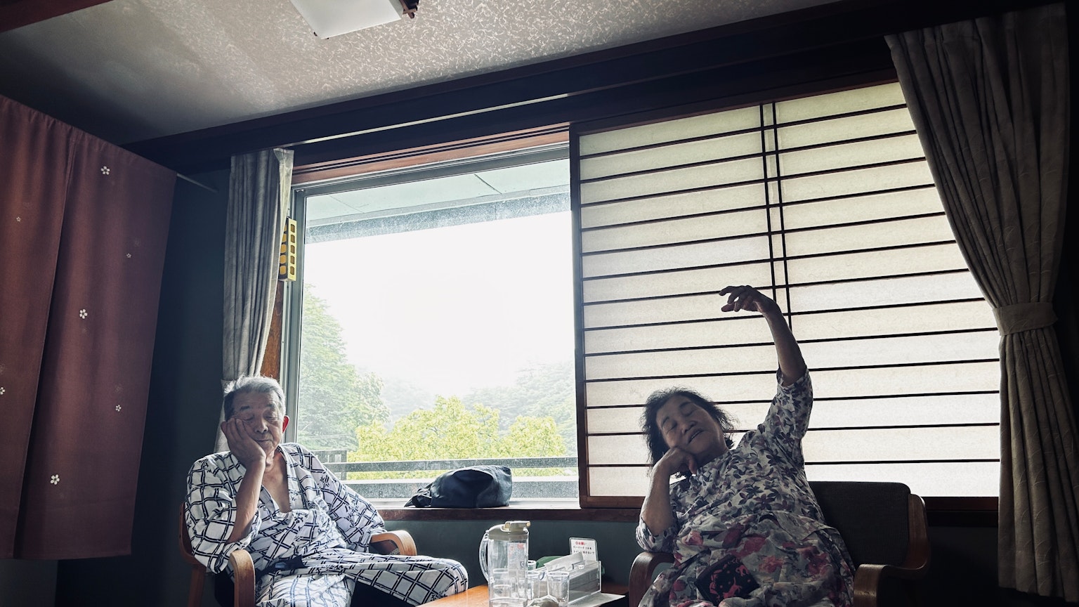 兩位女性在傳統日本房間的窗邊放鬆