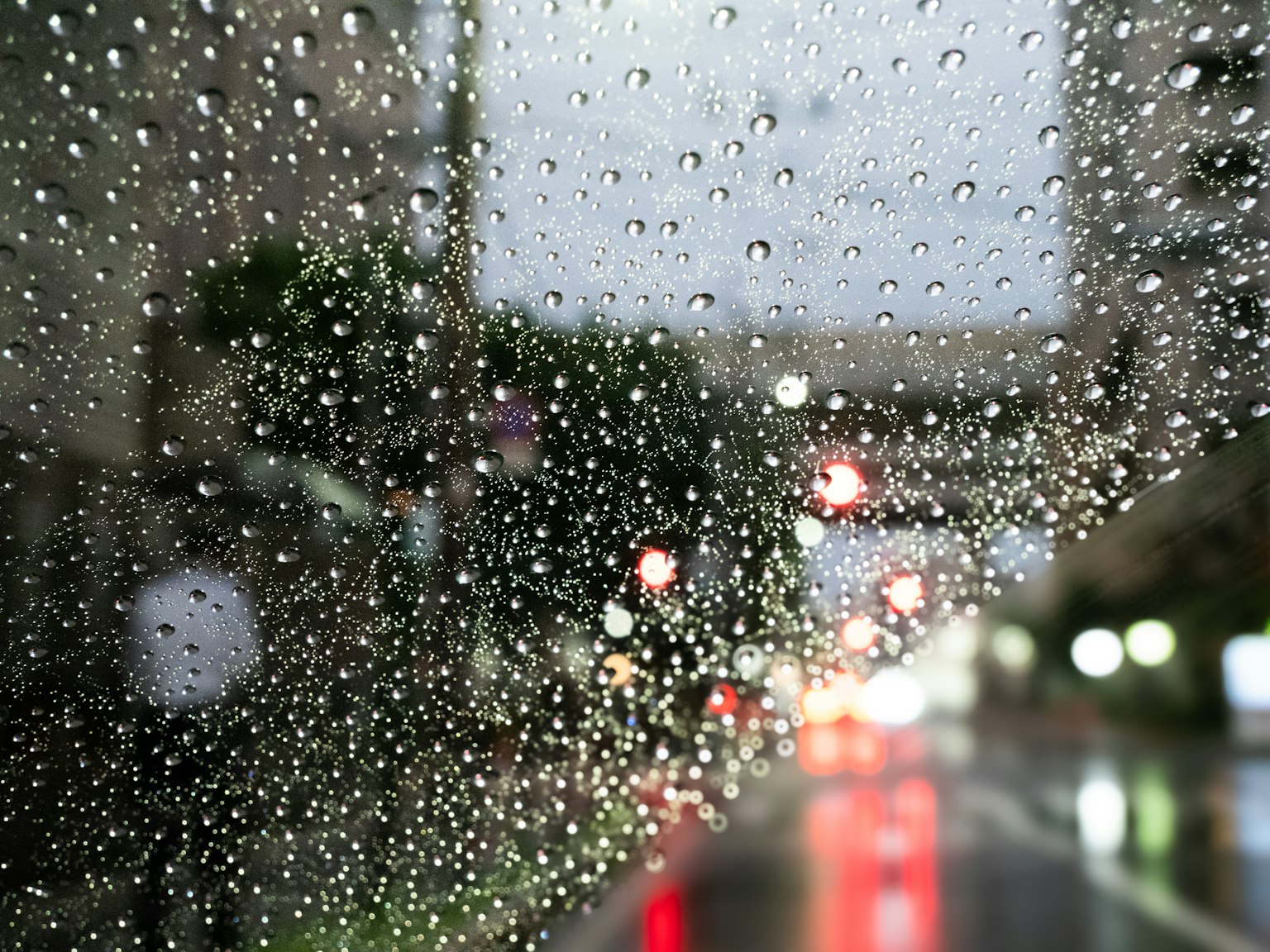 Verschwommene Stadtansicht durch ein mit Regentropfen bedecktes Fenster