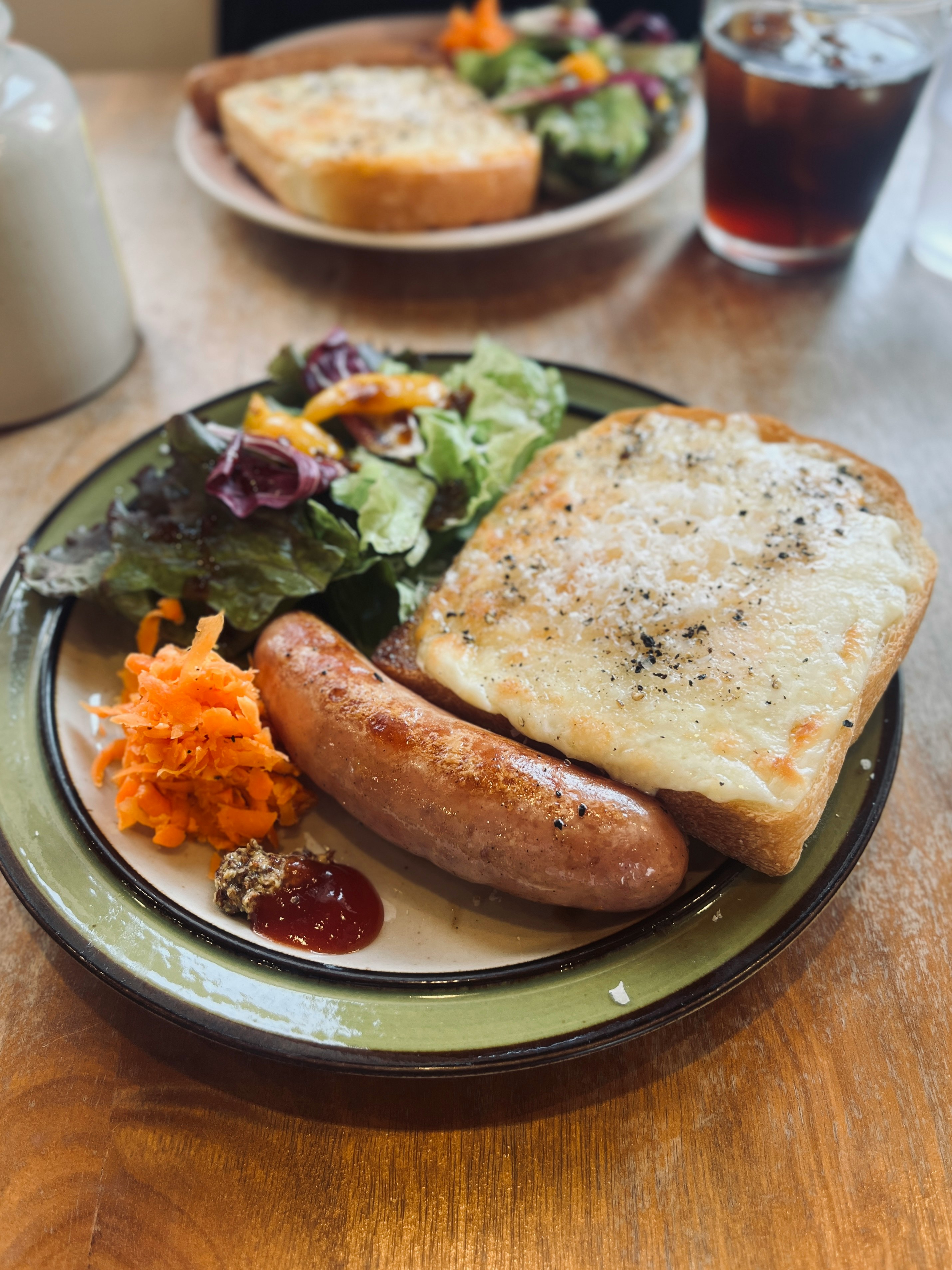 一盤包含香腸、沙拉和麵包的餐點