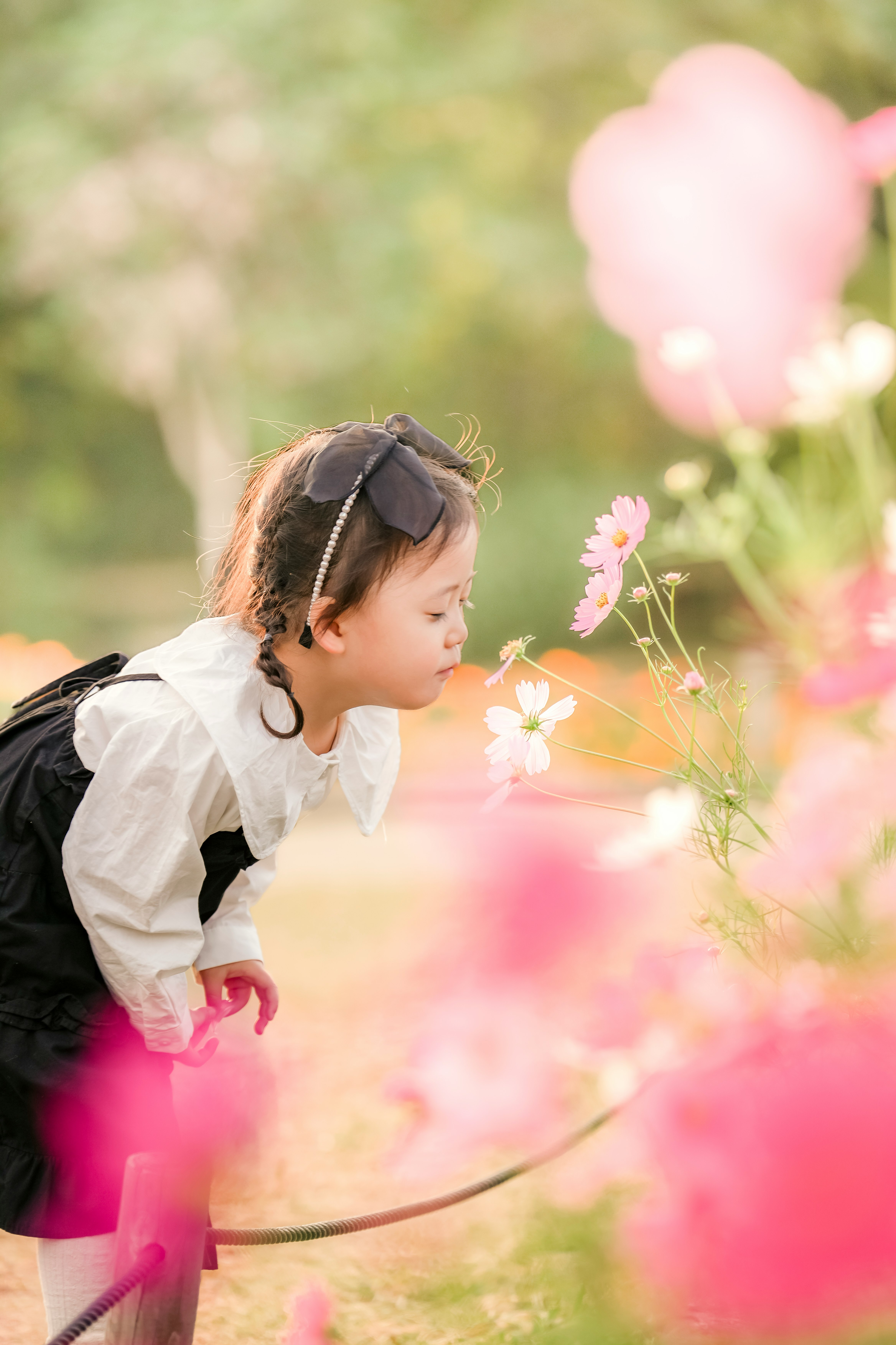 ピンクの花の中で歩く子どもの横顔