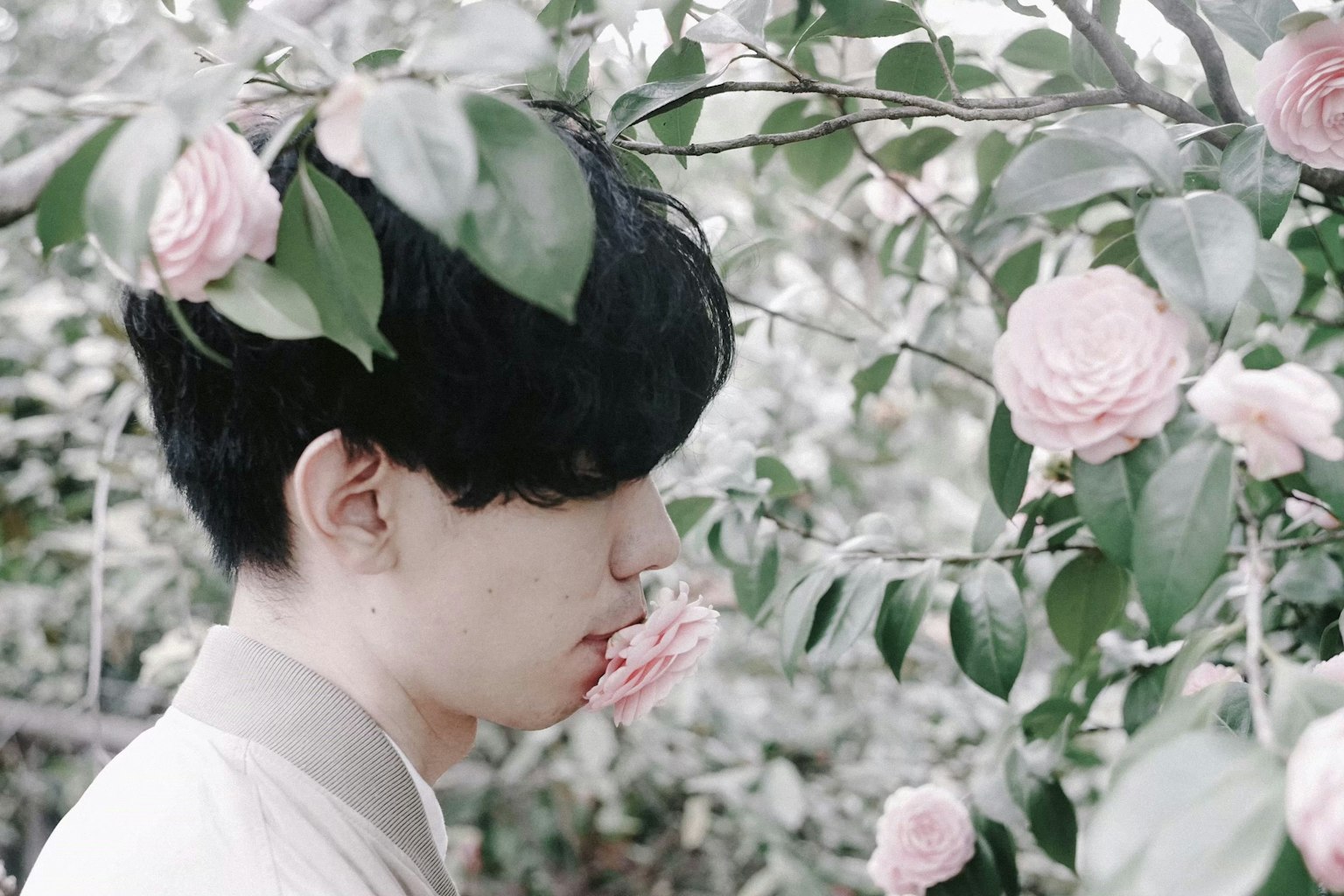 젊은 남자가 꽃 근처에서 조용히 서 있다