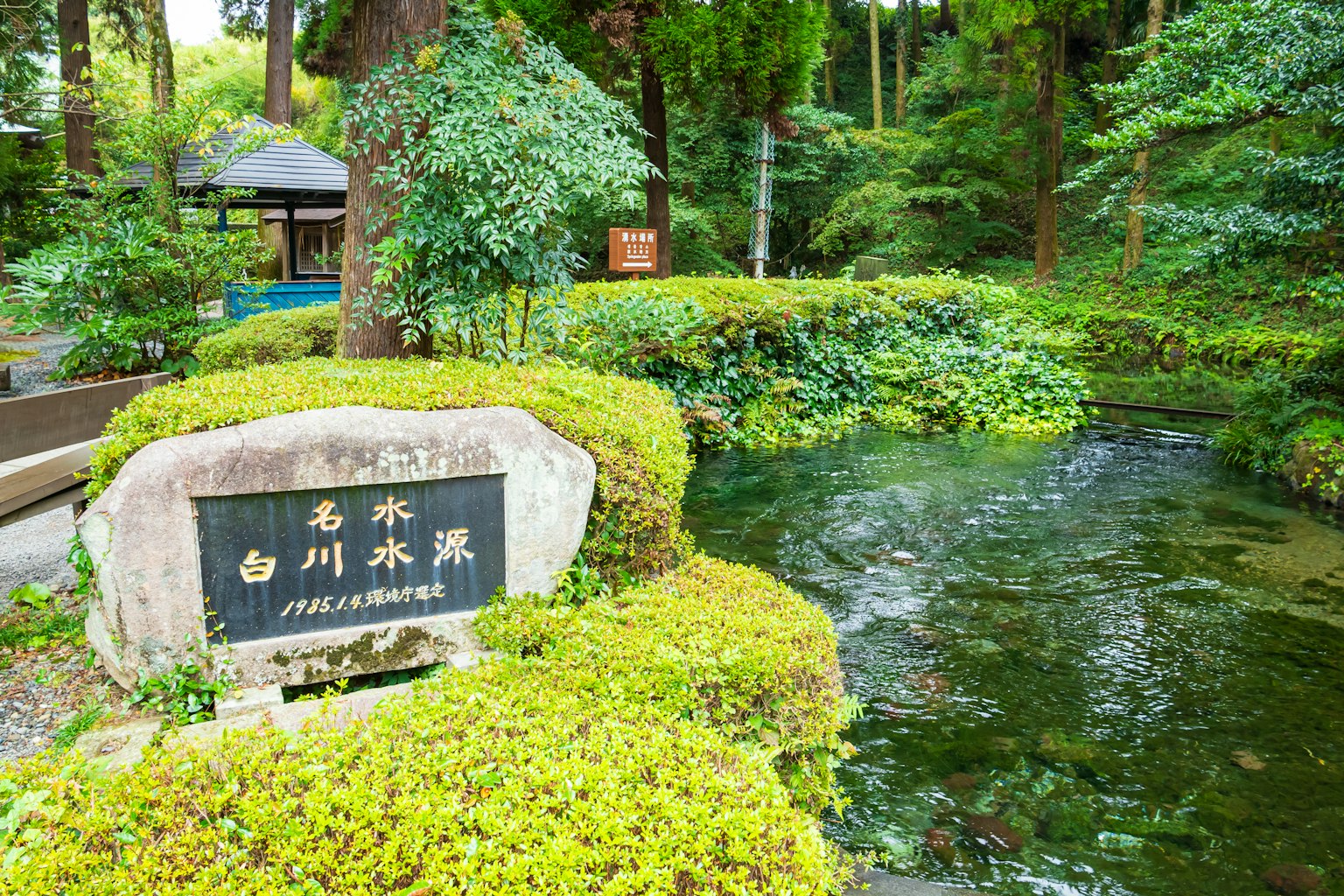 Vista escénica de un estanque de jardín con un cartel de piedra