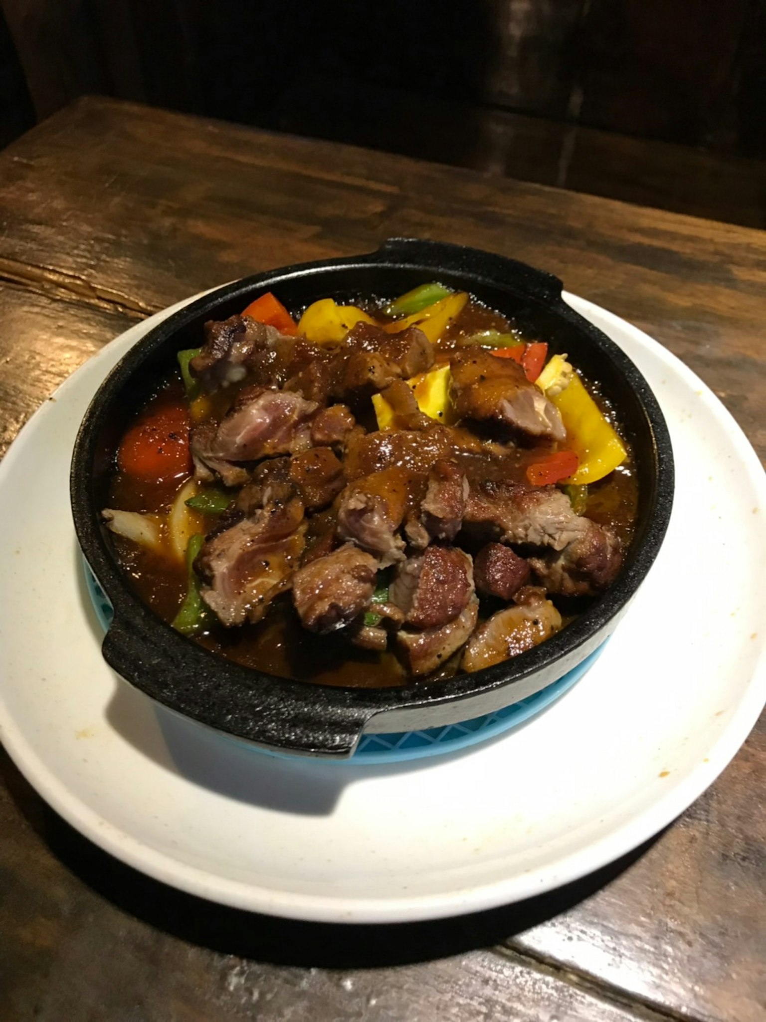 热气腾腾的肉和蔬菜菜肴在铸铁锅中