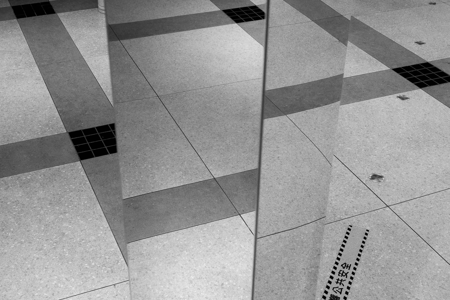 鏡の反射とタイルのパターンが交差するモダンな室内の床