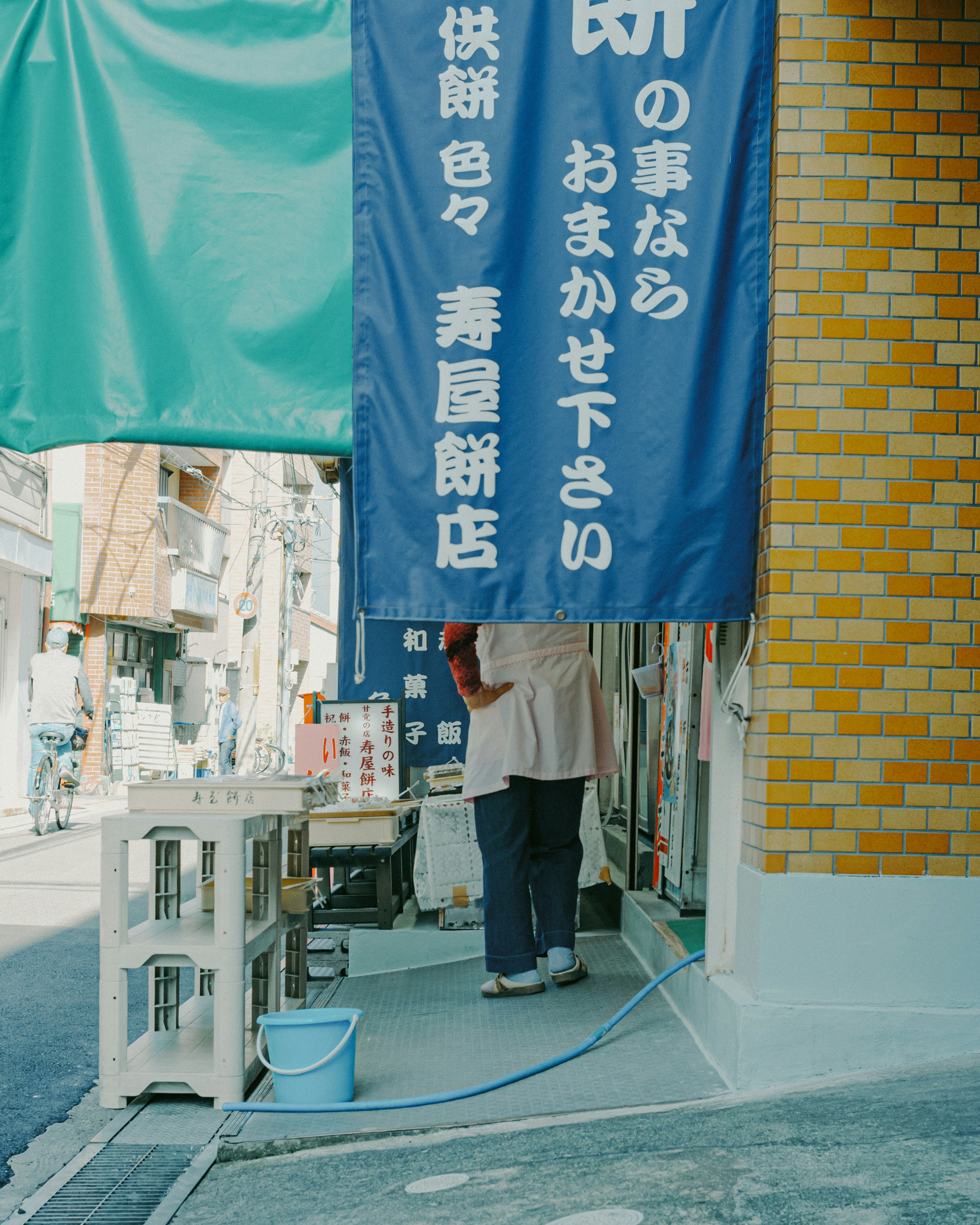 青い暖簾のある路地の屋台と椅子