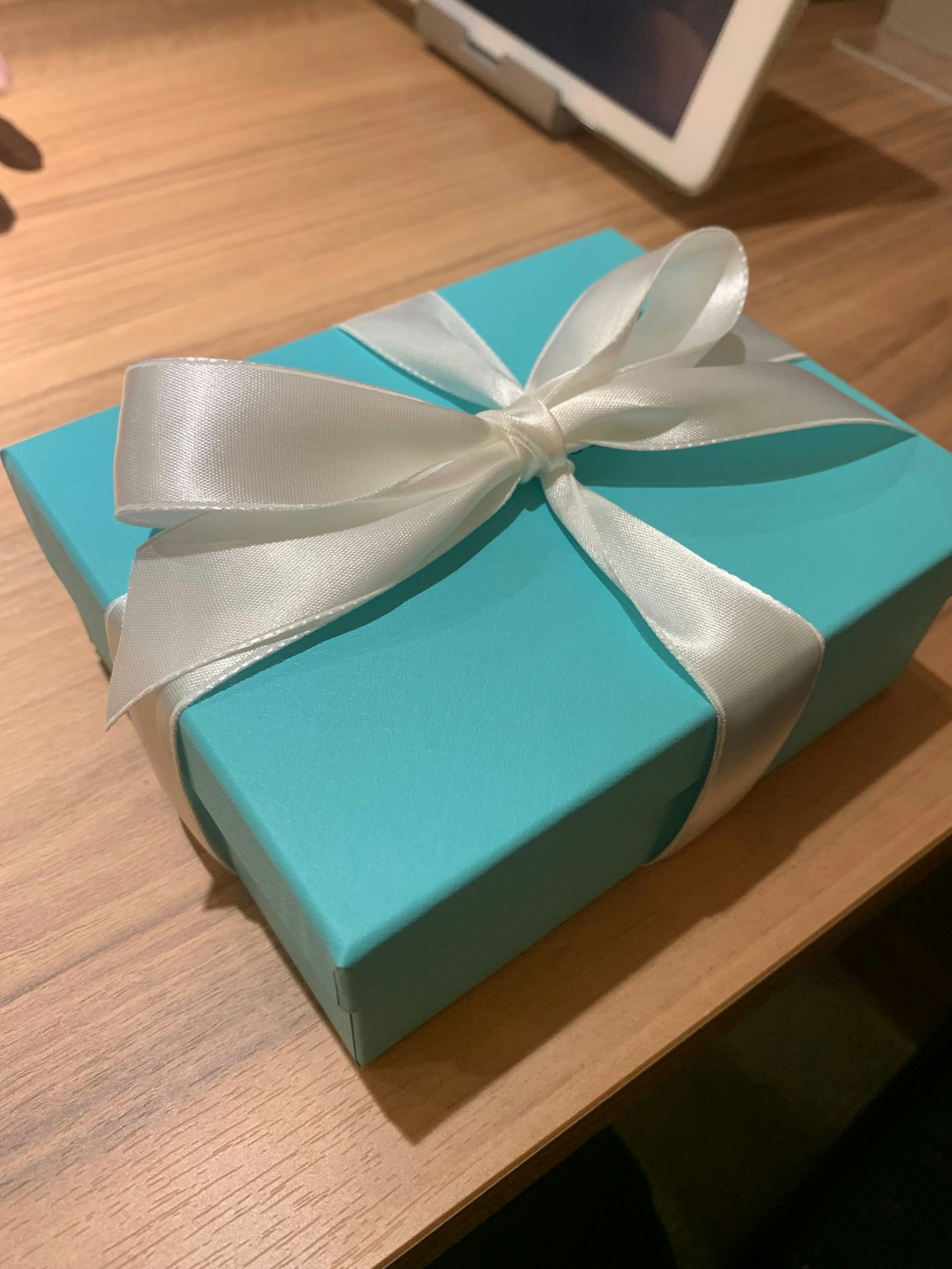 Caja de regalo azul Tiffany atada con una cinta blanca