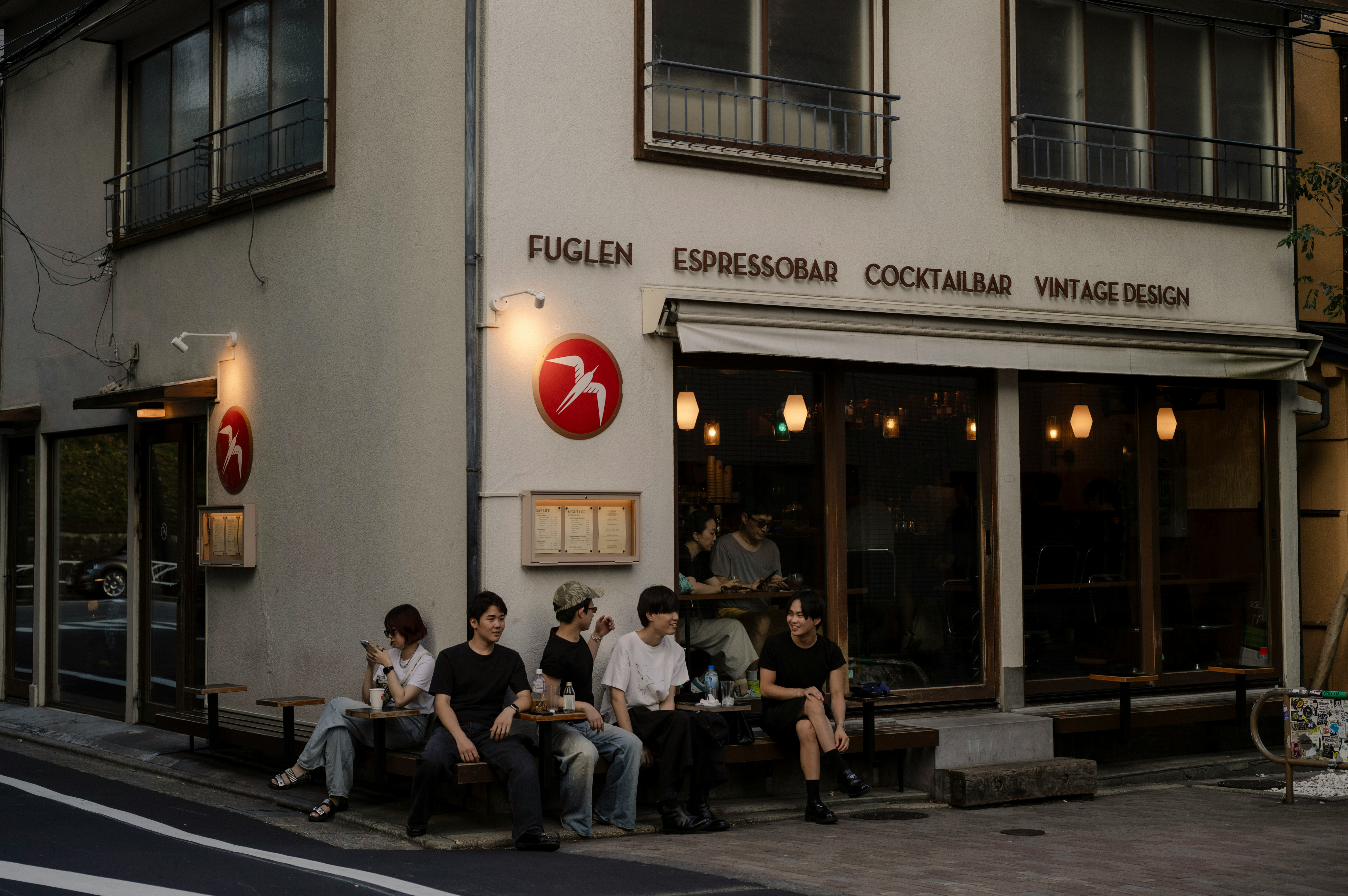 路地のカフェ前で人が集まる屋外のテーブル席