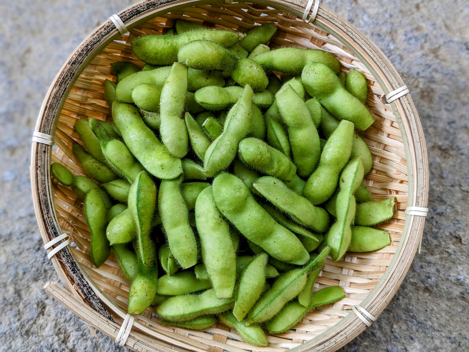 新鲜的绿毛豆放在编织的篮子里