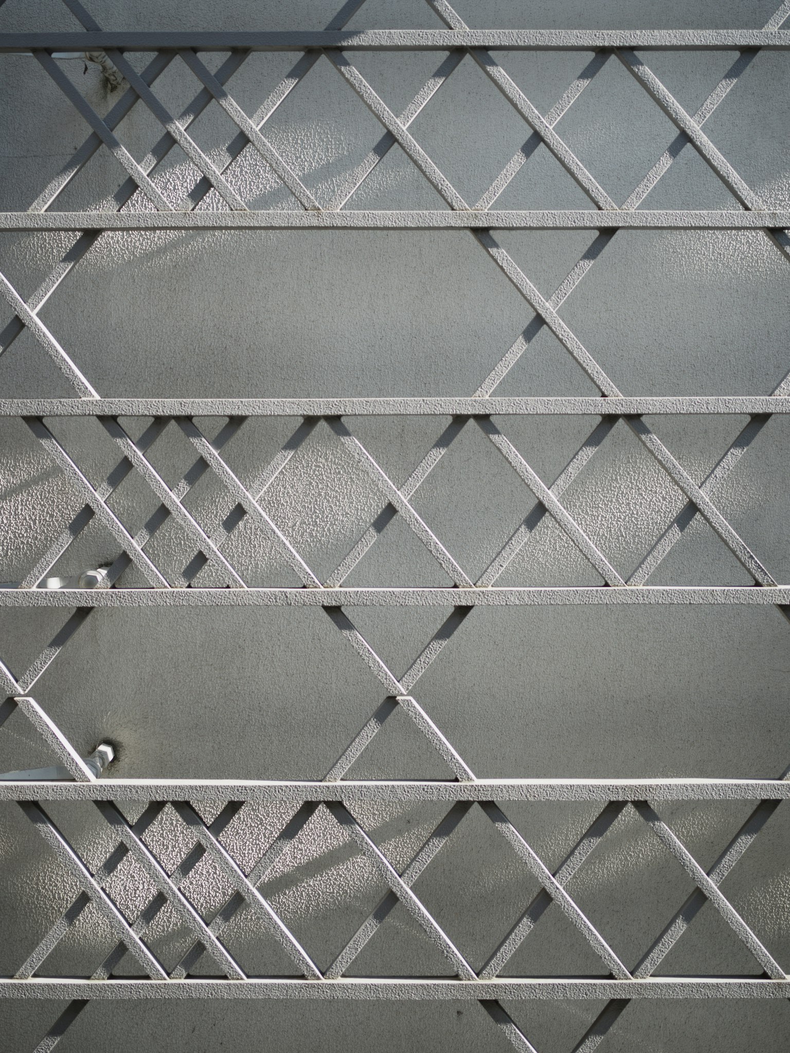 Metallgitterwanddesign mit einem Muster aus diagonalen Linien und Schatten