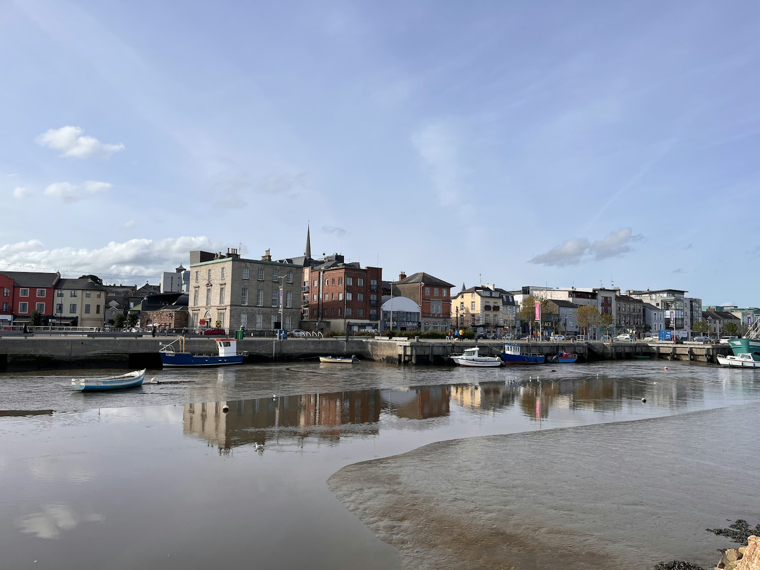 Town view with river reflections and calm clouds