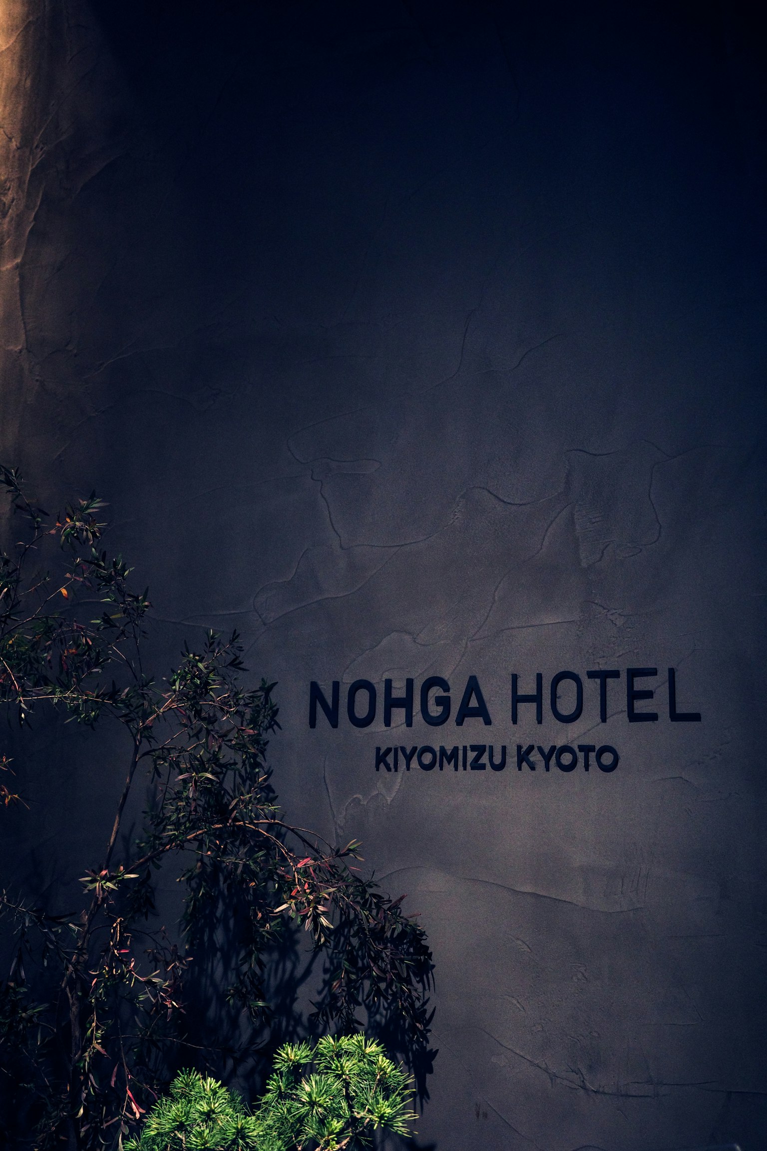 Insegna dell'hotel Nohga a Kyoto con vegetazione circostante