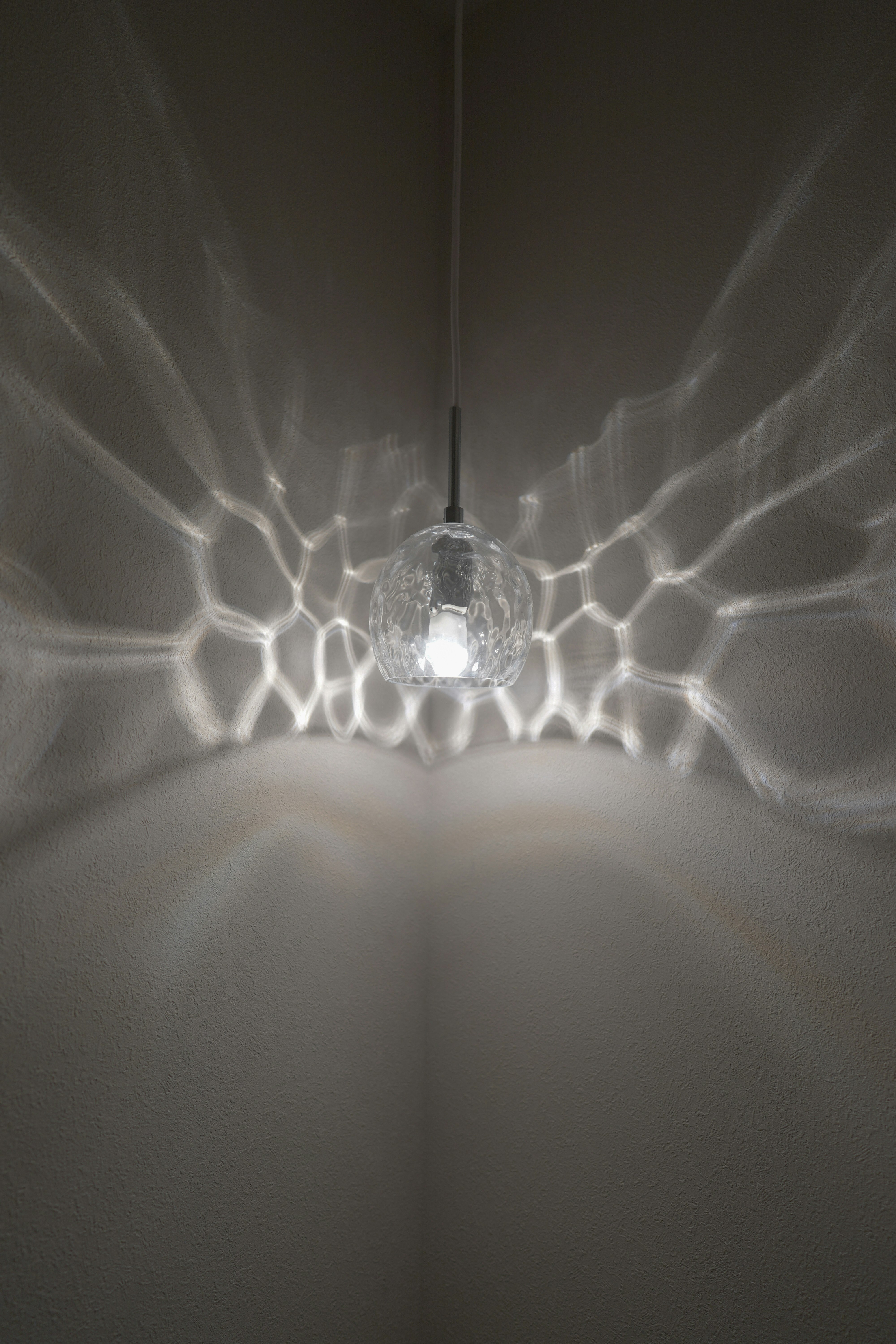 Aqua pendant light casting radial beams of light