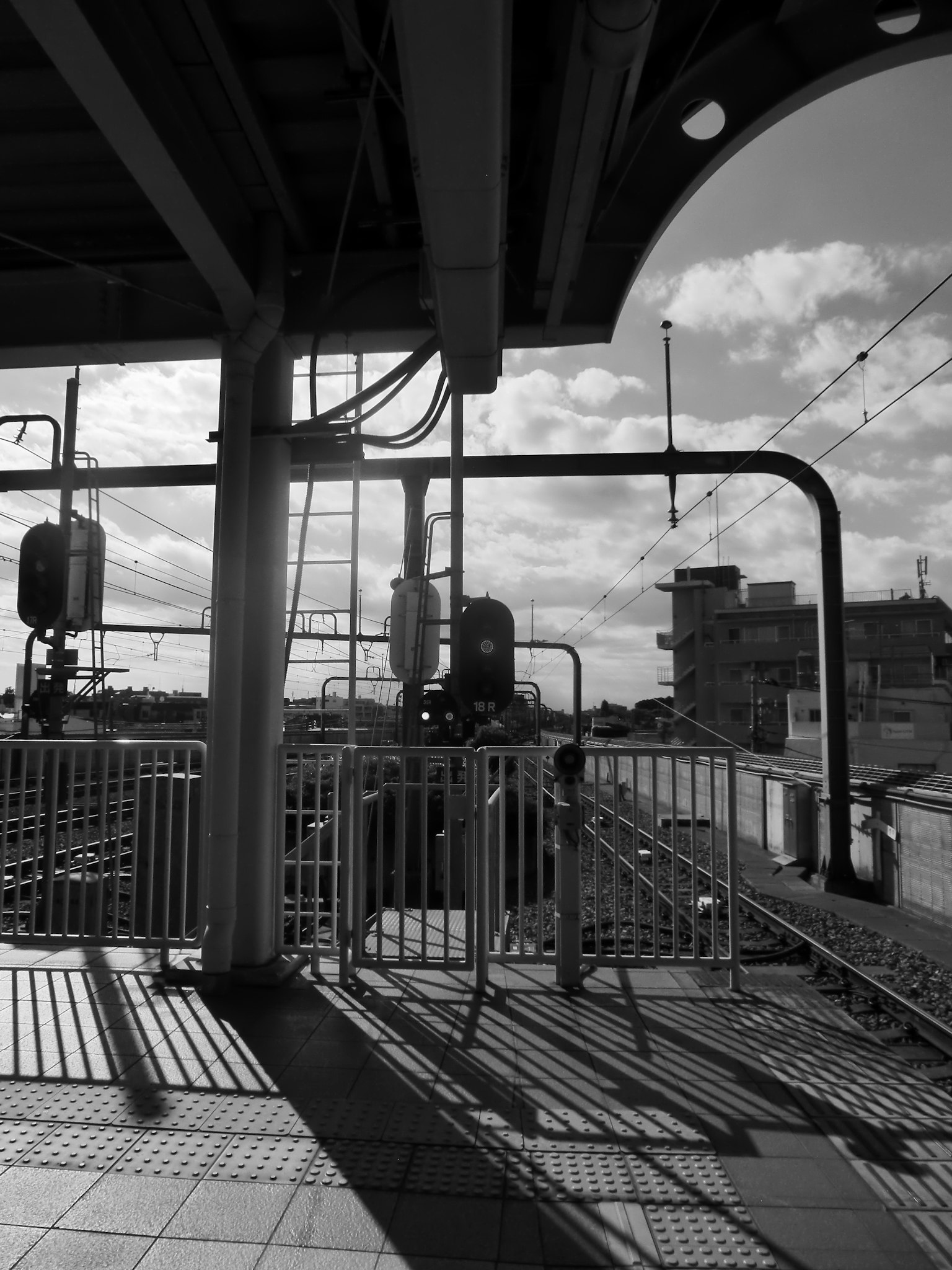 Schwarzweißfoto einer Bahnsteig mit strukturellen Elementen und Schatten