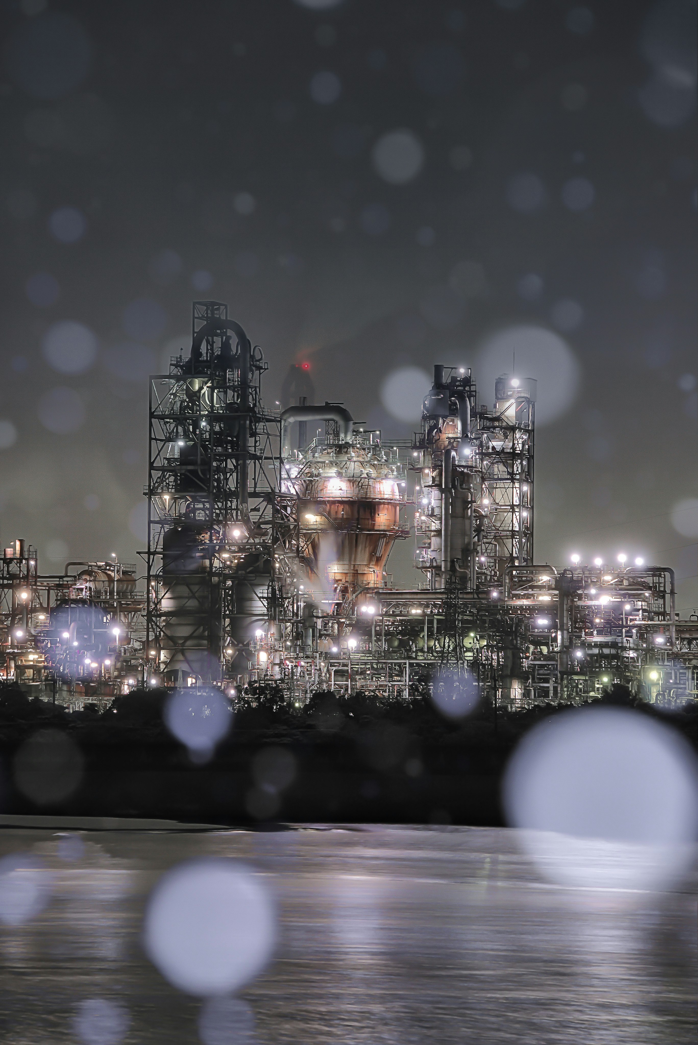 夜の工業プラントの夜景と煙突群