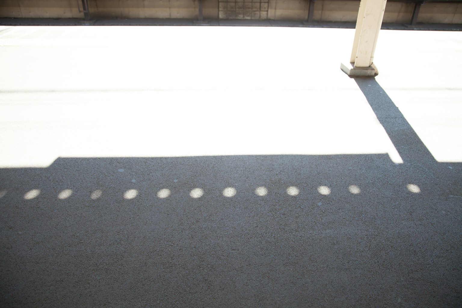 Shadows cast on a white floor with a column structure