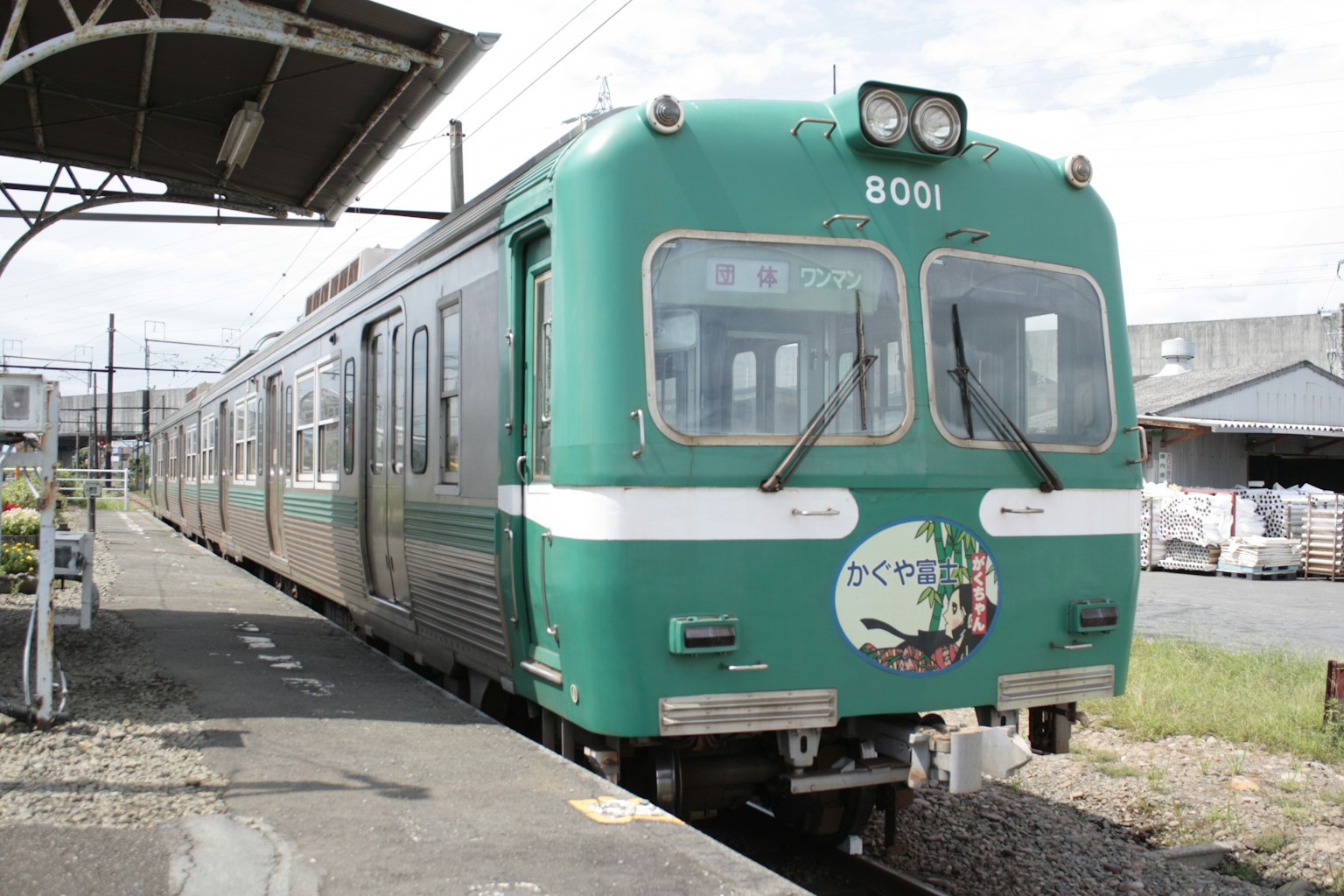 รถไฟสีเขียวจอดอยู่ที่สถานีมีภาพประกอบที่ด้านหน้า