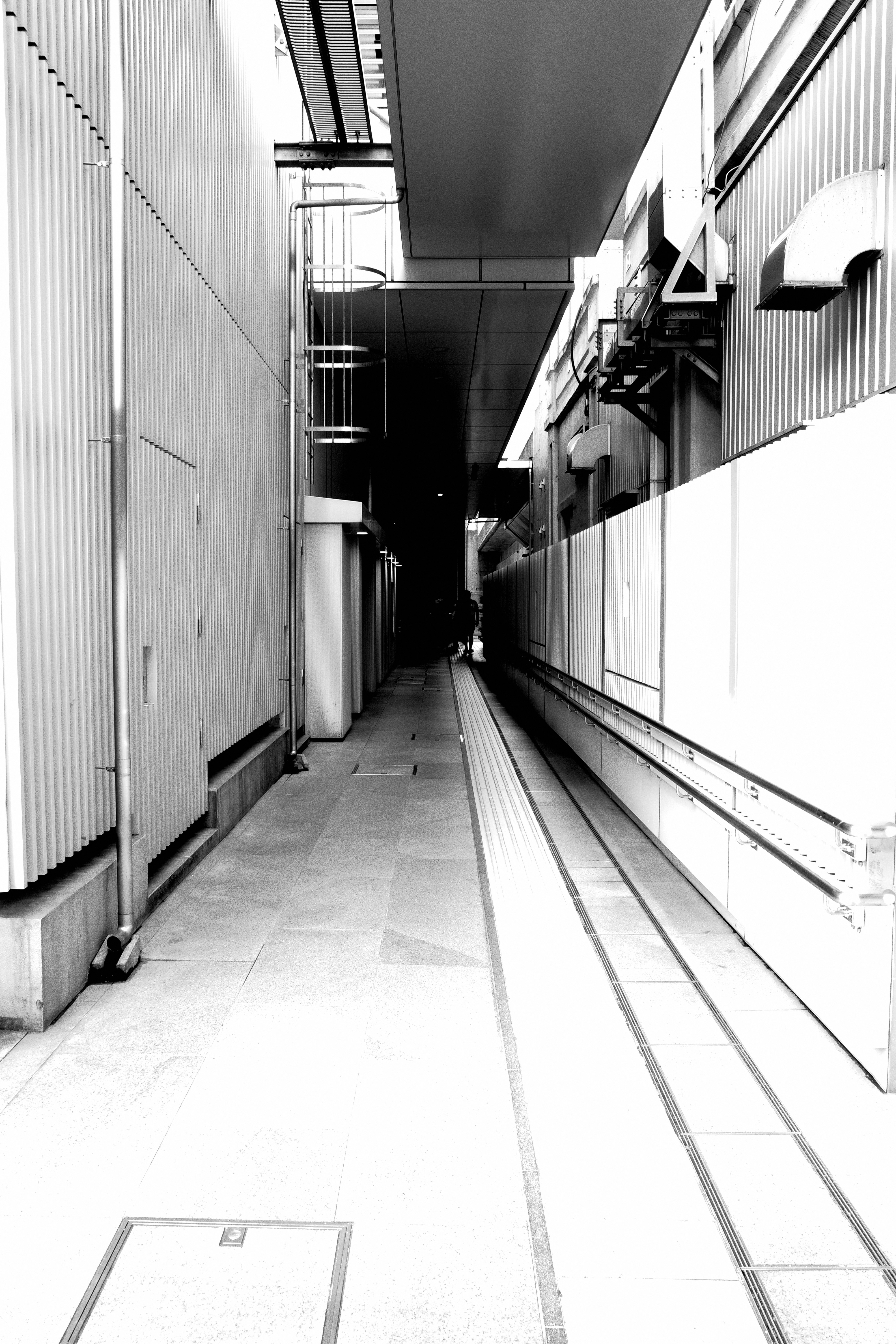 Lorong sempit di samping bangunan dalam hitam putih