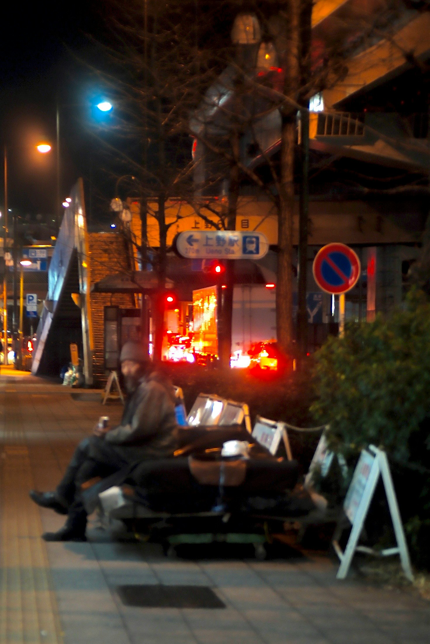 夜の街角でベンチに座る人々と街灯の明かり