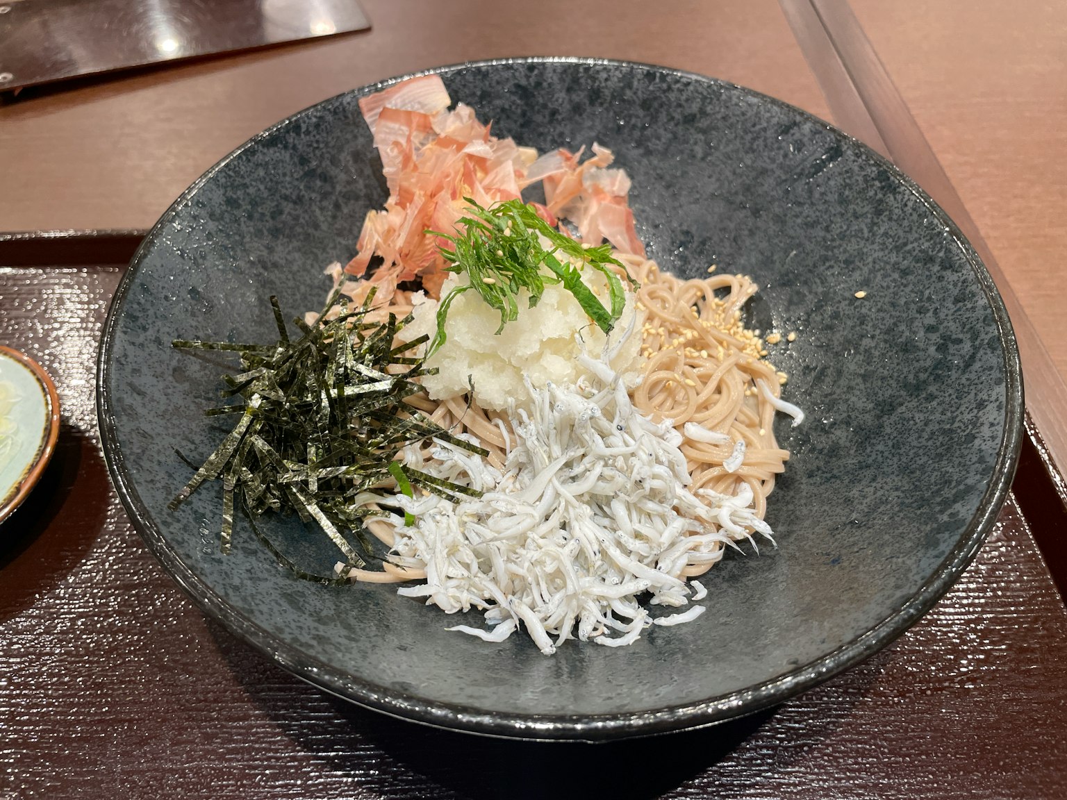 Hidangan mie dingin disajikan dalam mangkuk hitam