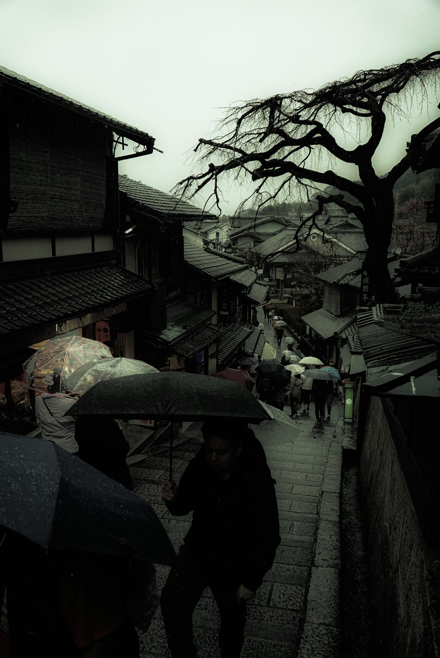 雨中历史街景，人们撑着伞